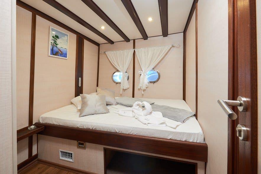 a bed with a white sheet and a white bed spread aboard NAUTILUS Yacht for Charter