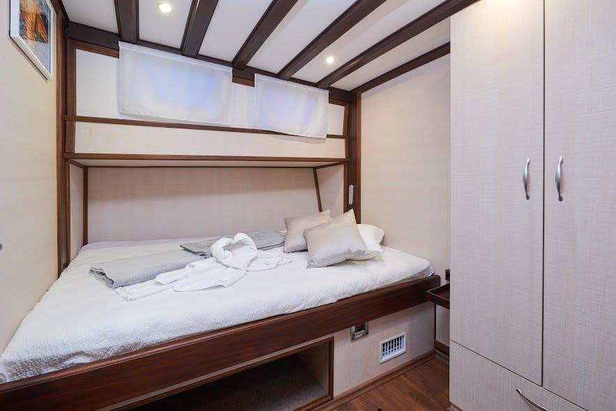 a bed with a white cover aboard NAUTILUS Yacht for Charter