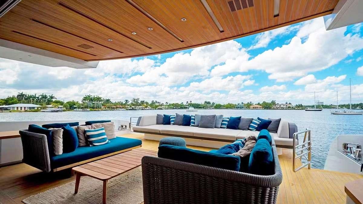 a large patio with a large patio area with a large pool and a deck with boats and trees aboard CYRA Yacht for Charter