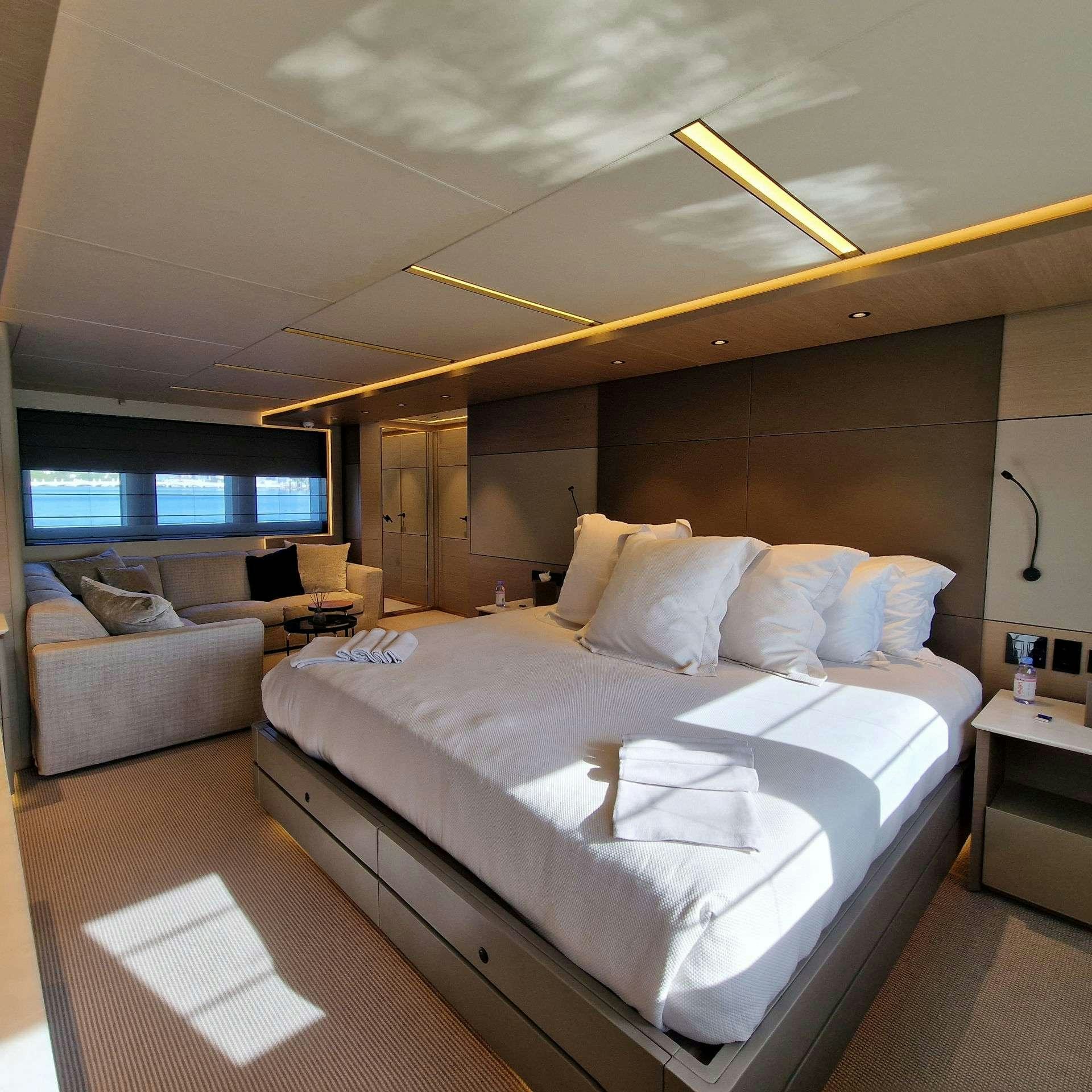 a room with a bed and a couch aboard CYRA Yacht for Charter