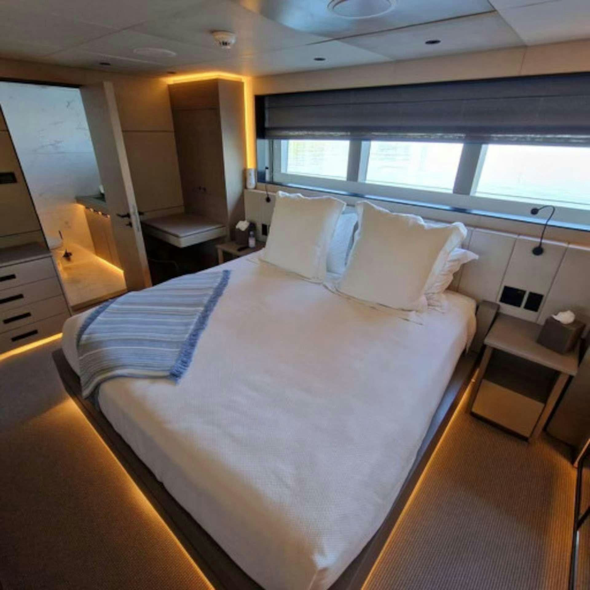a bed with white sheets aboard CYRA Yacht for Charter