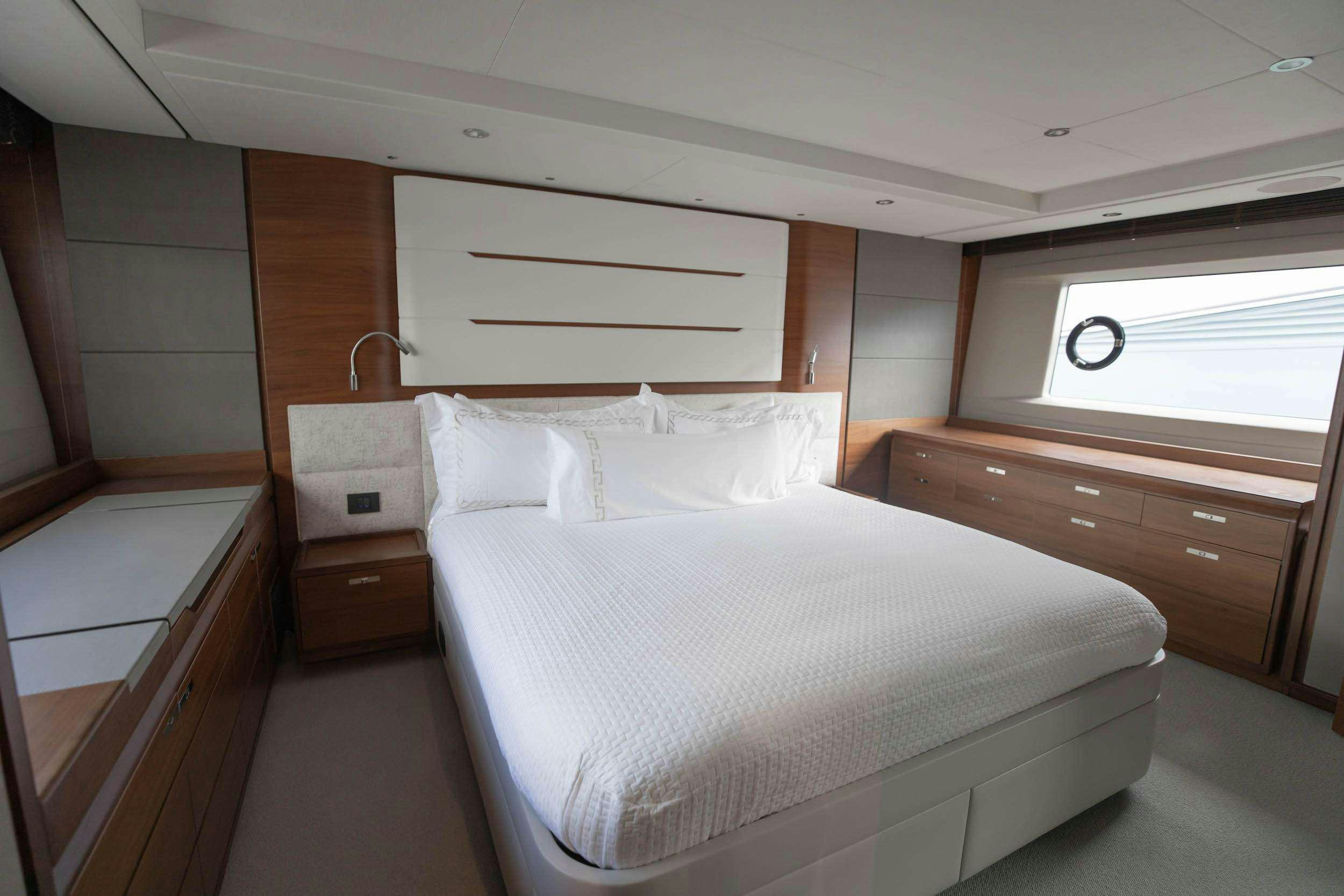 a bedroom with a bed and a dresser aboard SABLE Yacht for Charter