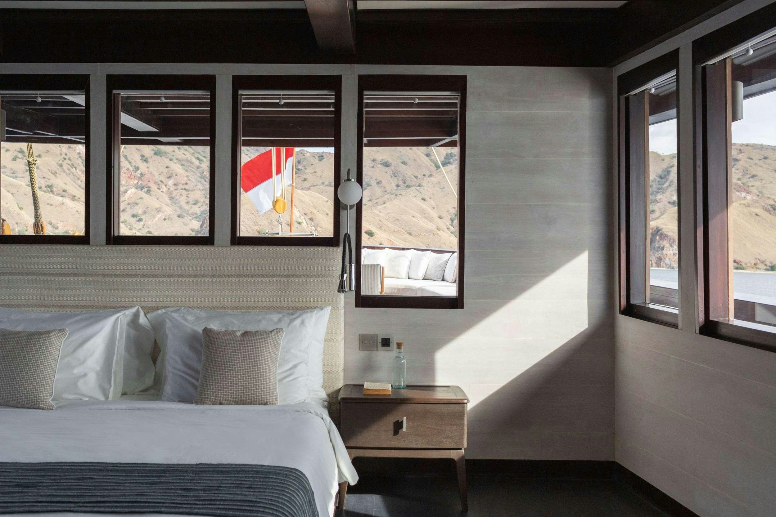 a room with a bed and a window aboard VELA Yacht for Charter