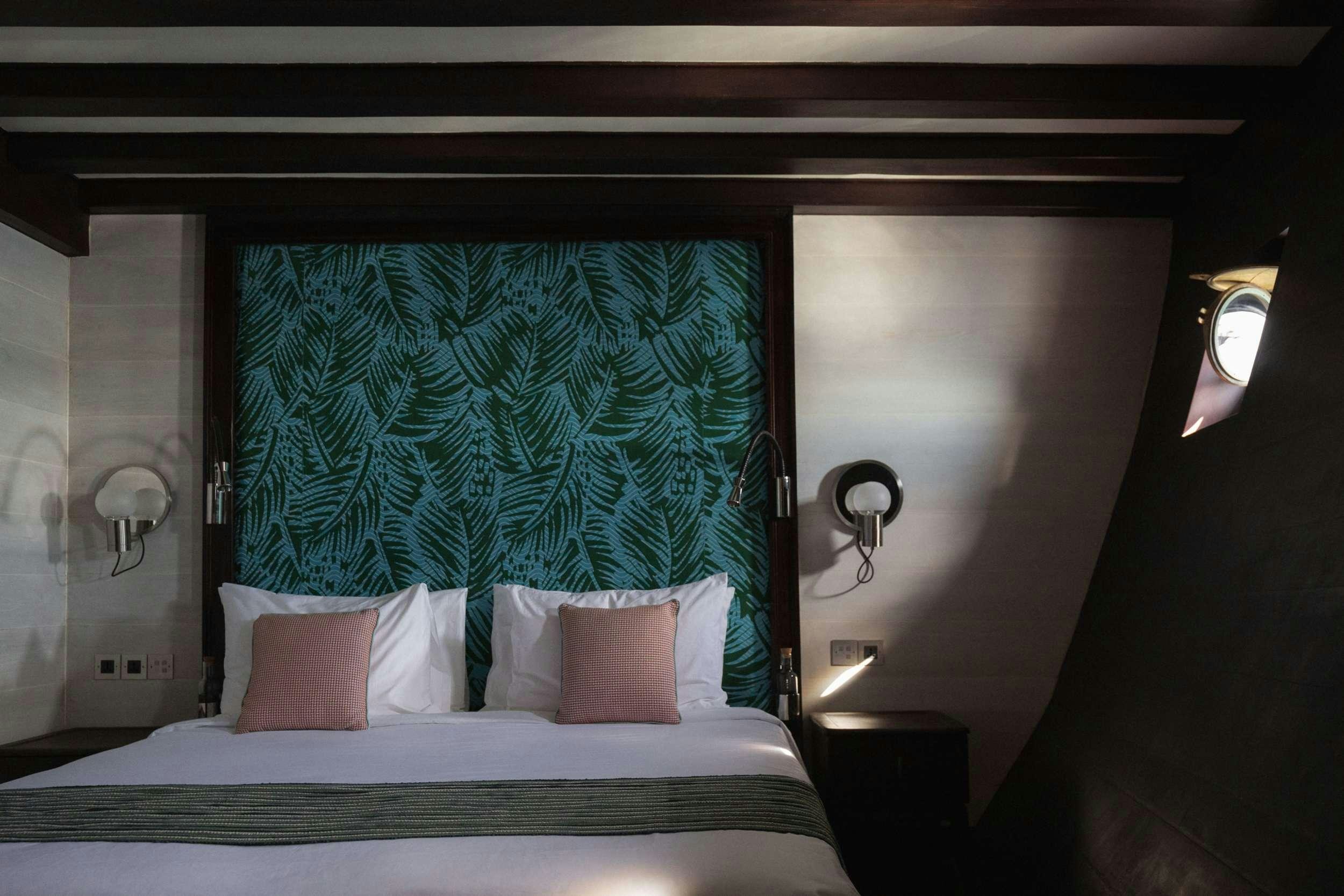 a bed with a painting on the wall aboard VELA Yacht for Charter