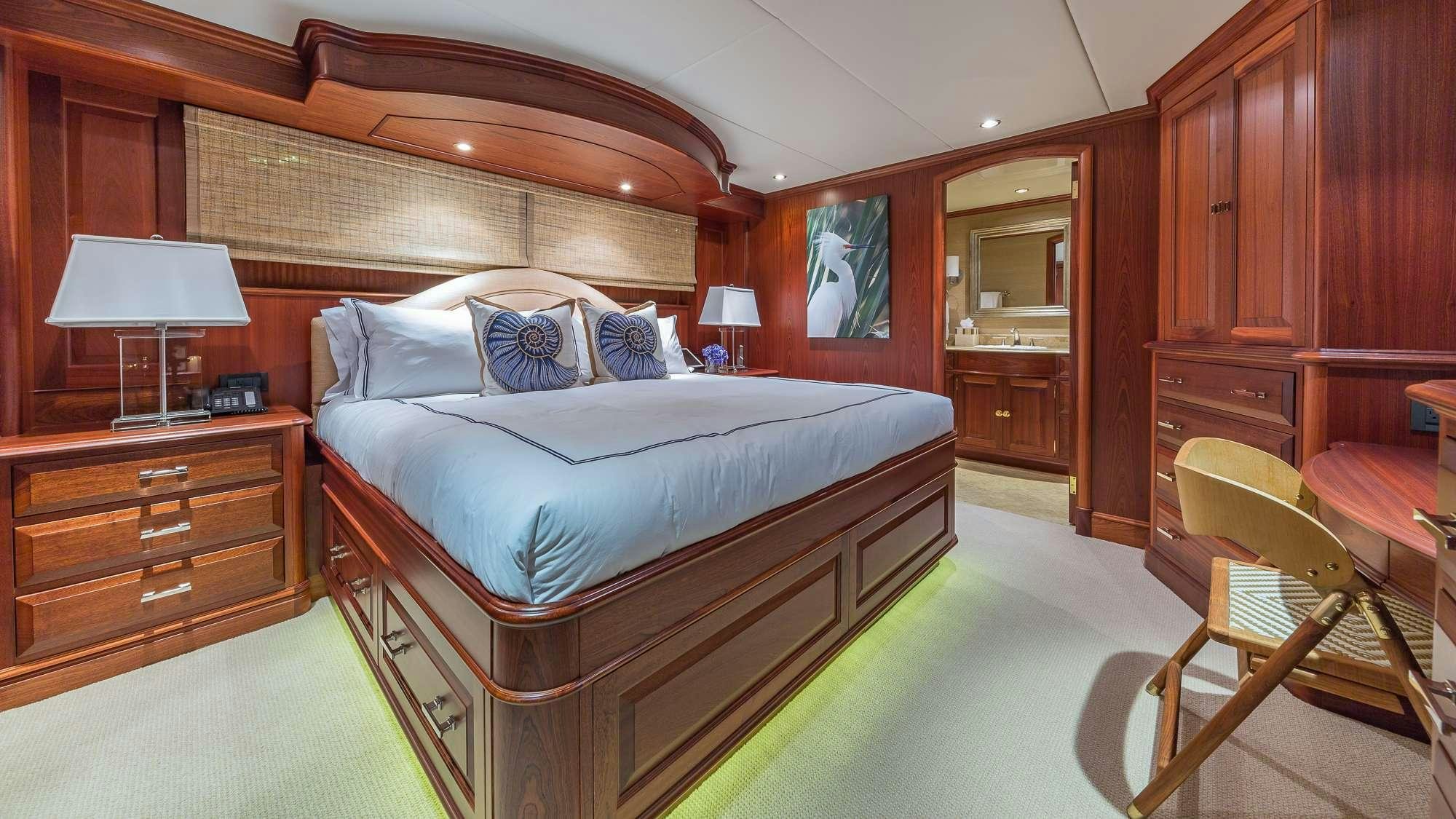 a bedroom with a bed and a desk aboard KING OF FUN Yacht for Charter