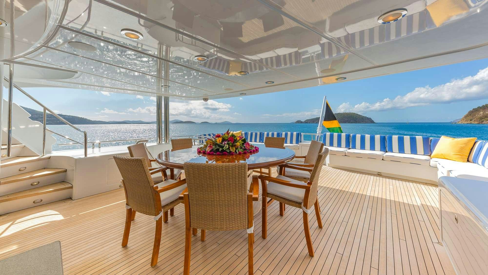 a table and chairs on a deck aboard KING OF FUN Yacht for Charter