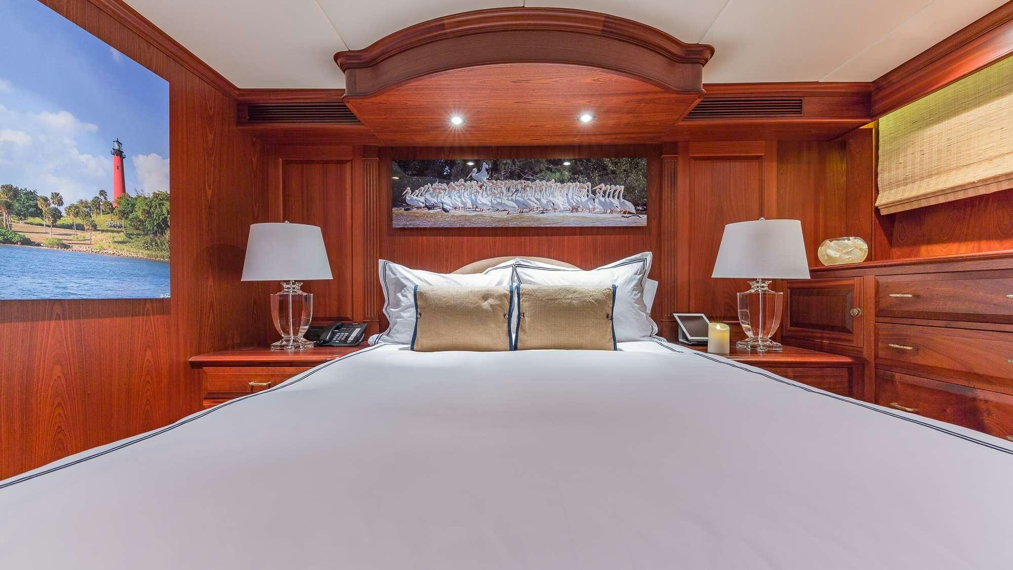 a bed with a large wooden headboard and a large wooden headboard aboard KING OF FUN Yacht for Charter