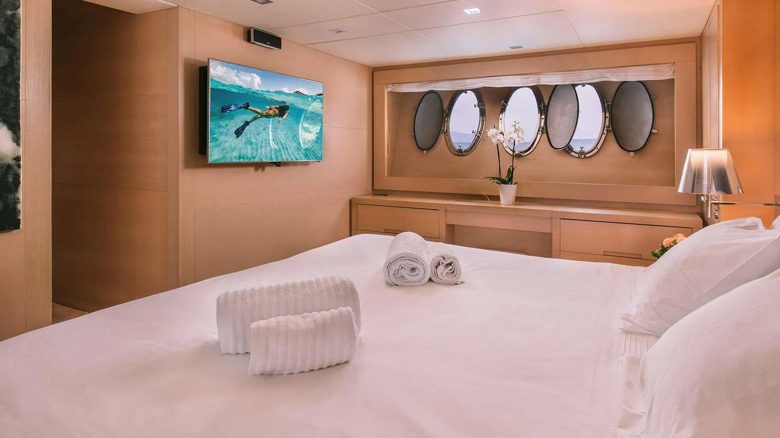 a bed with white sheets and pillows aboard SEAS THE DAY Yacht for Charter