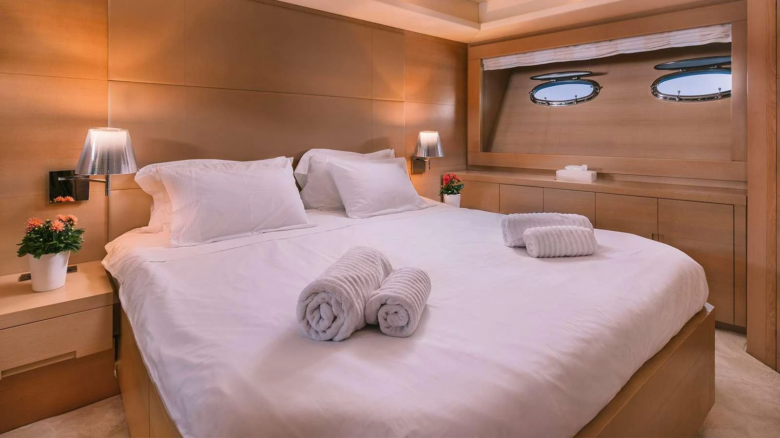 a bed with white sheets and pillows aboard SEAS THE DAY Yacht for Charter