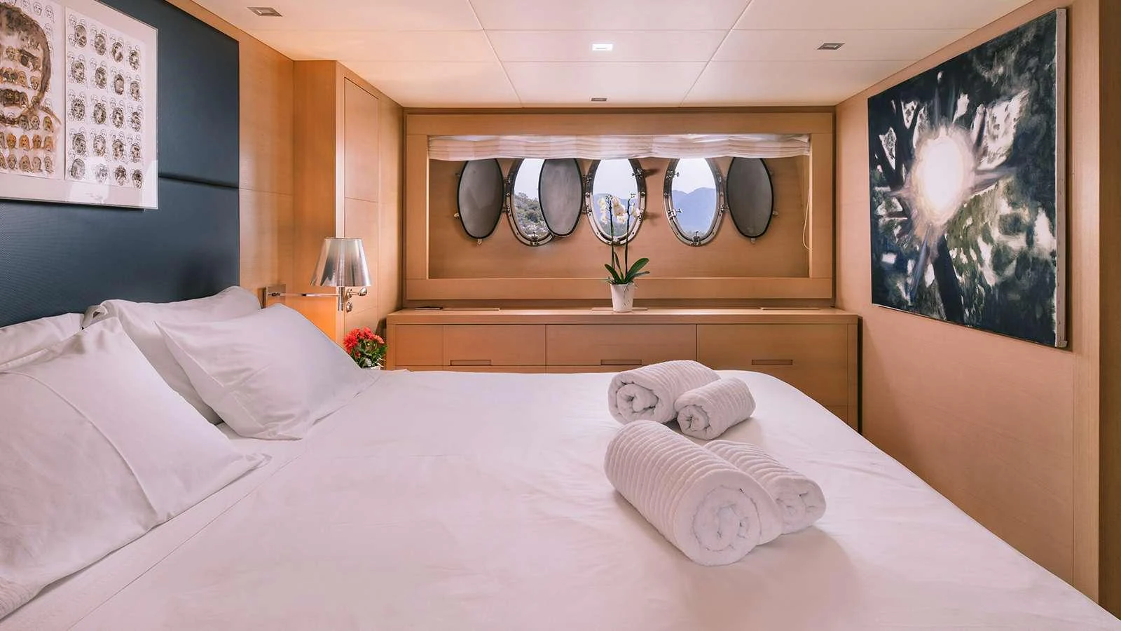 a bed with white sheets and pillows aboard SEAS THE DAY Yacht for Charter