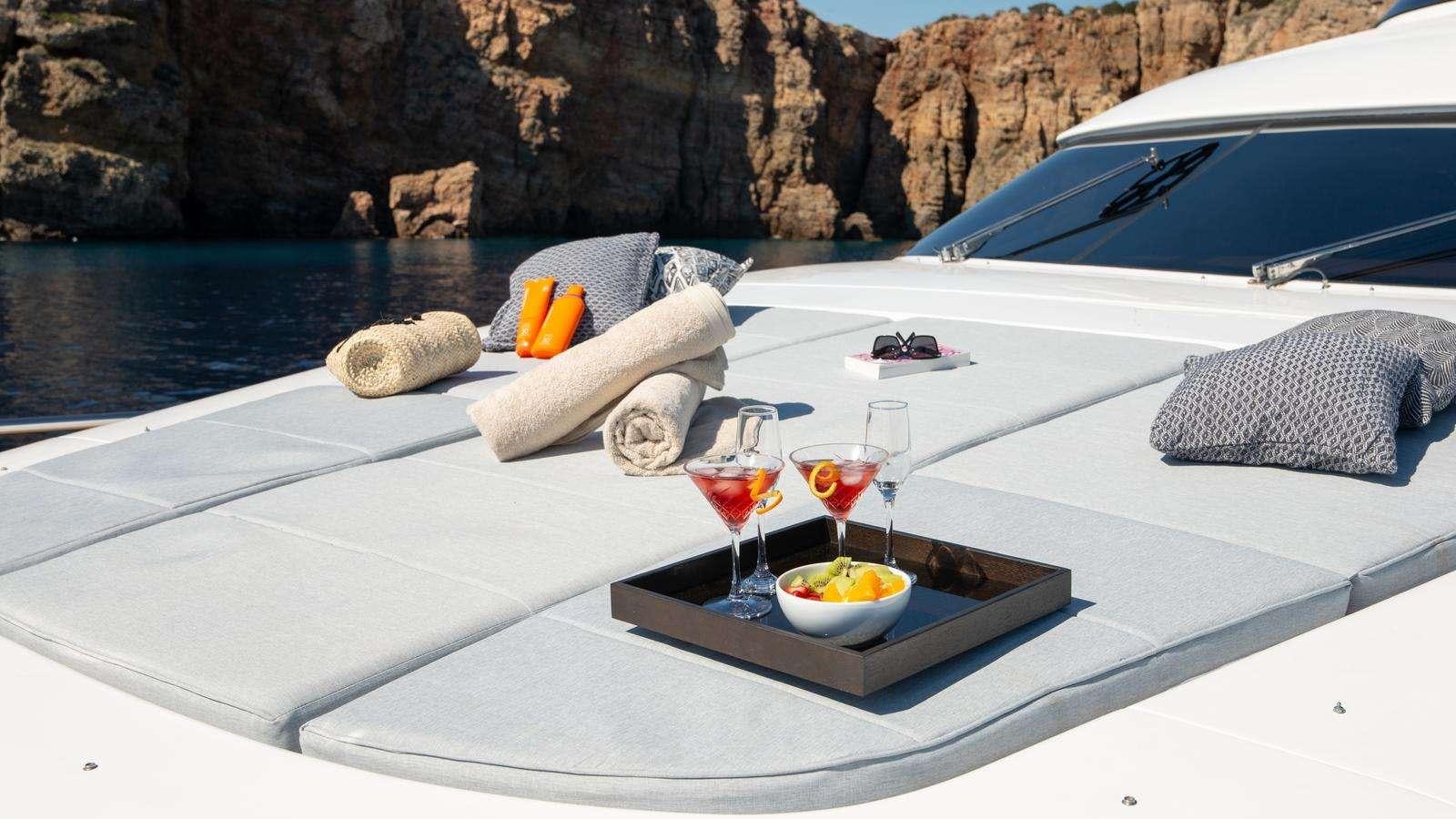 a table with a glass of wine and a tray of food on it aboard EL PECADO Yacht for Charter