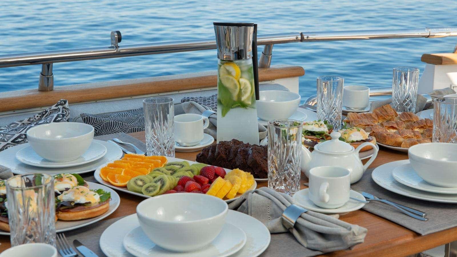 a table with food and glasses on it aboard EL PECADO Yacht for Charter