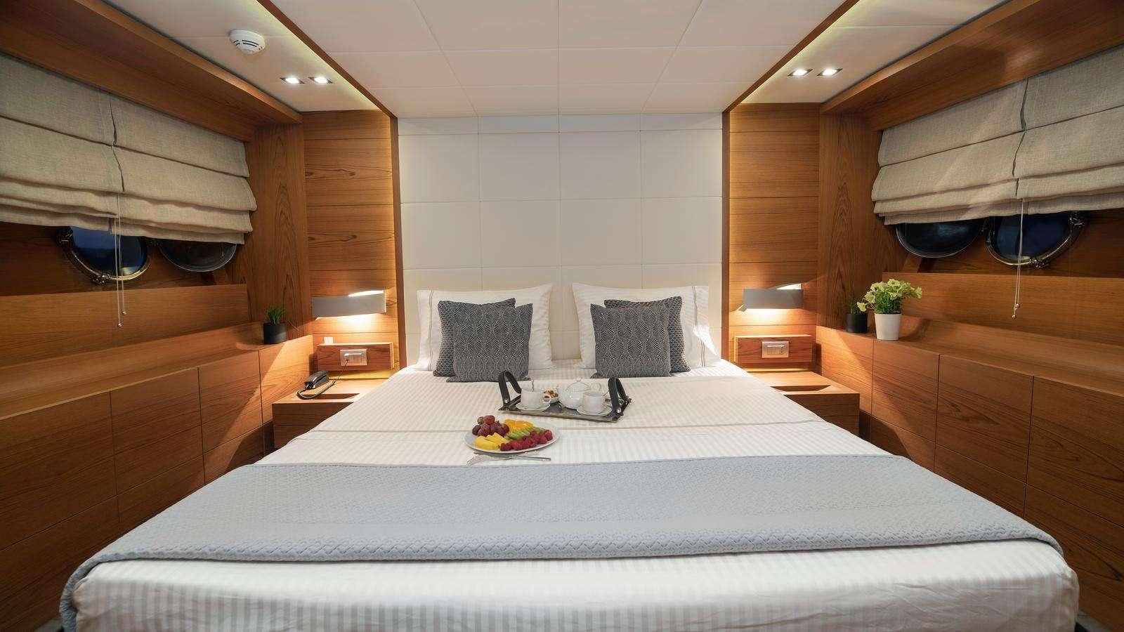 a bed with a tray of food aboard EL PECADO Yacht for Charter