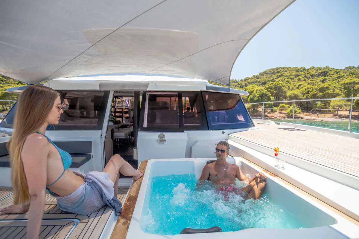 a couple of people sitting in a hot tub on a boat aboard MAJESTY OF GREECE Yacht for Charter