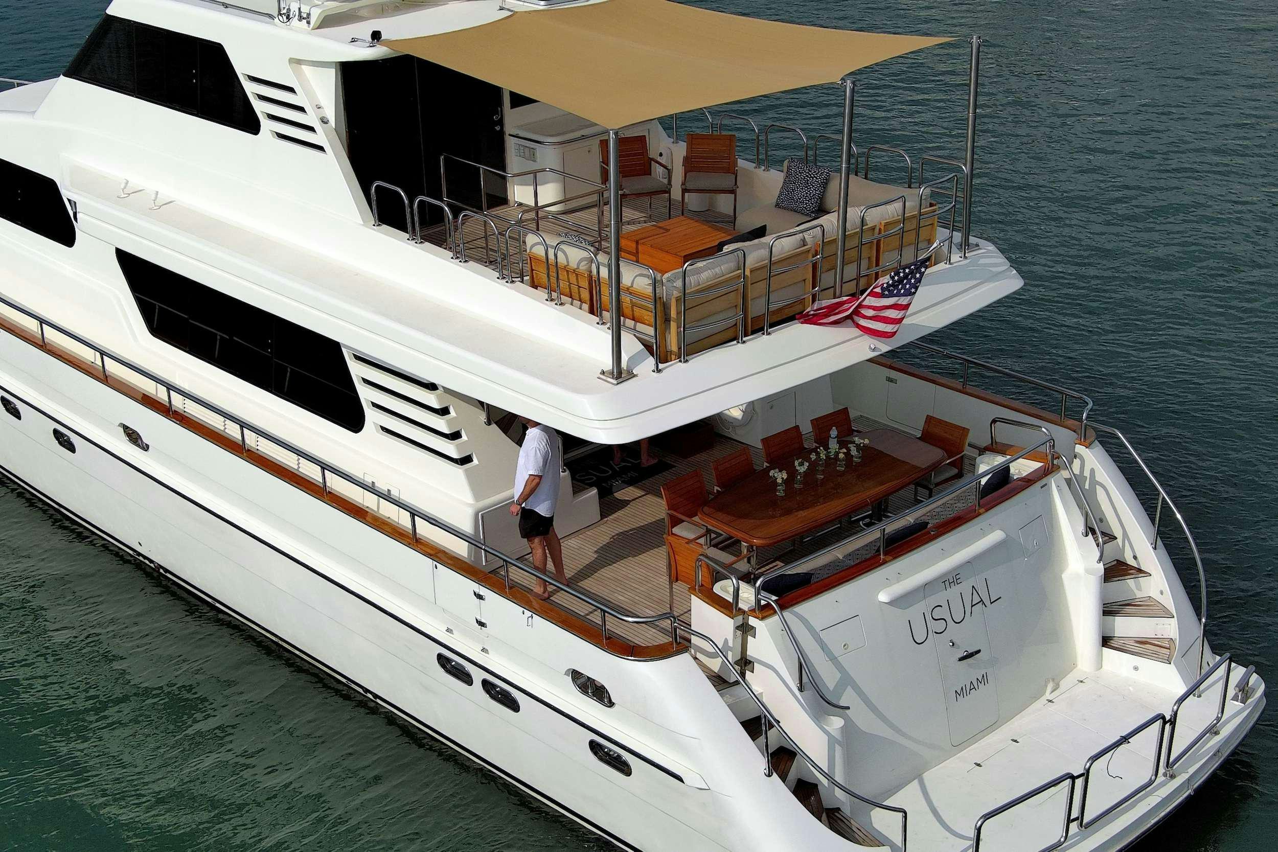 a large white boat with a person standing on the deck aboard THE USUAL Yacht for Charter