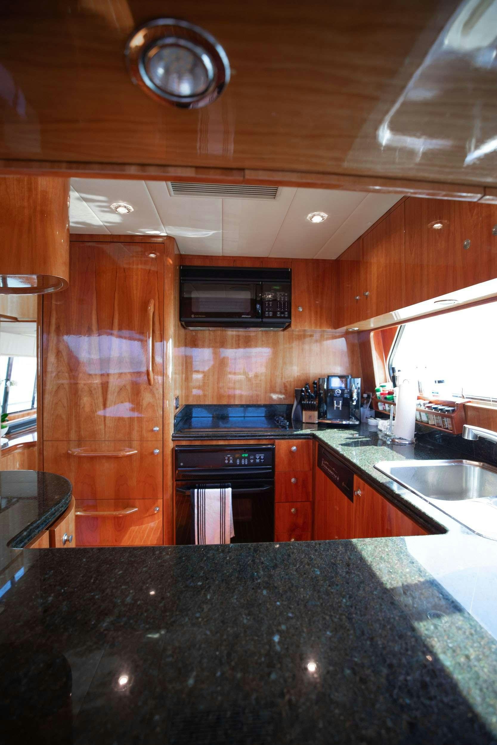 a kitchen with wooden cabinets aboard THE USUAL Yacht for Charter