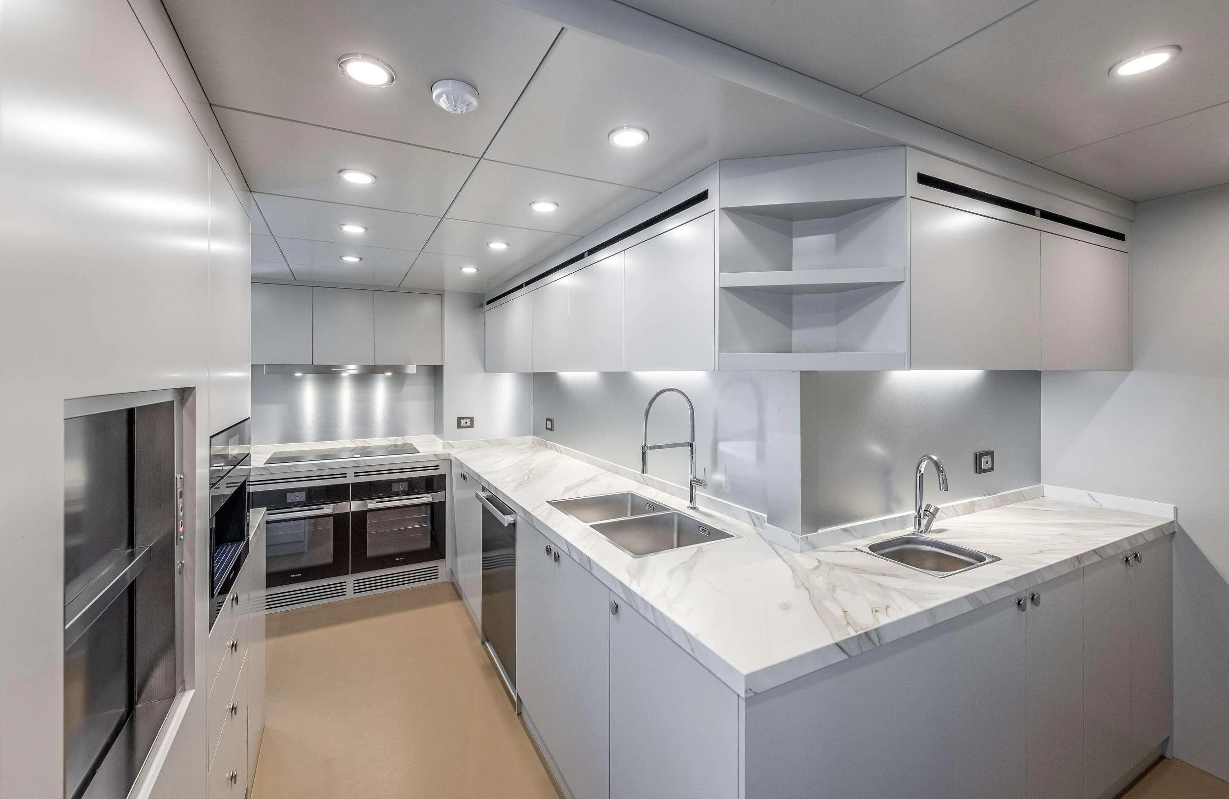 a kitchen with white cabinets aboard EAU LA LA Yacht for Charter