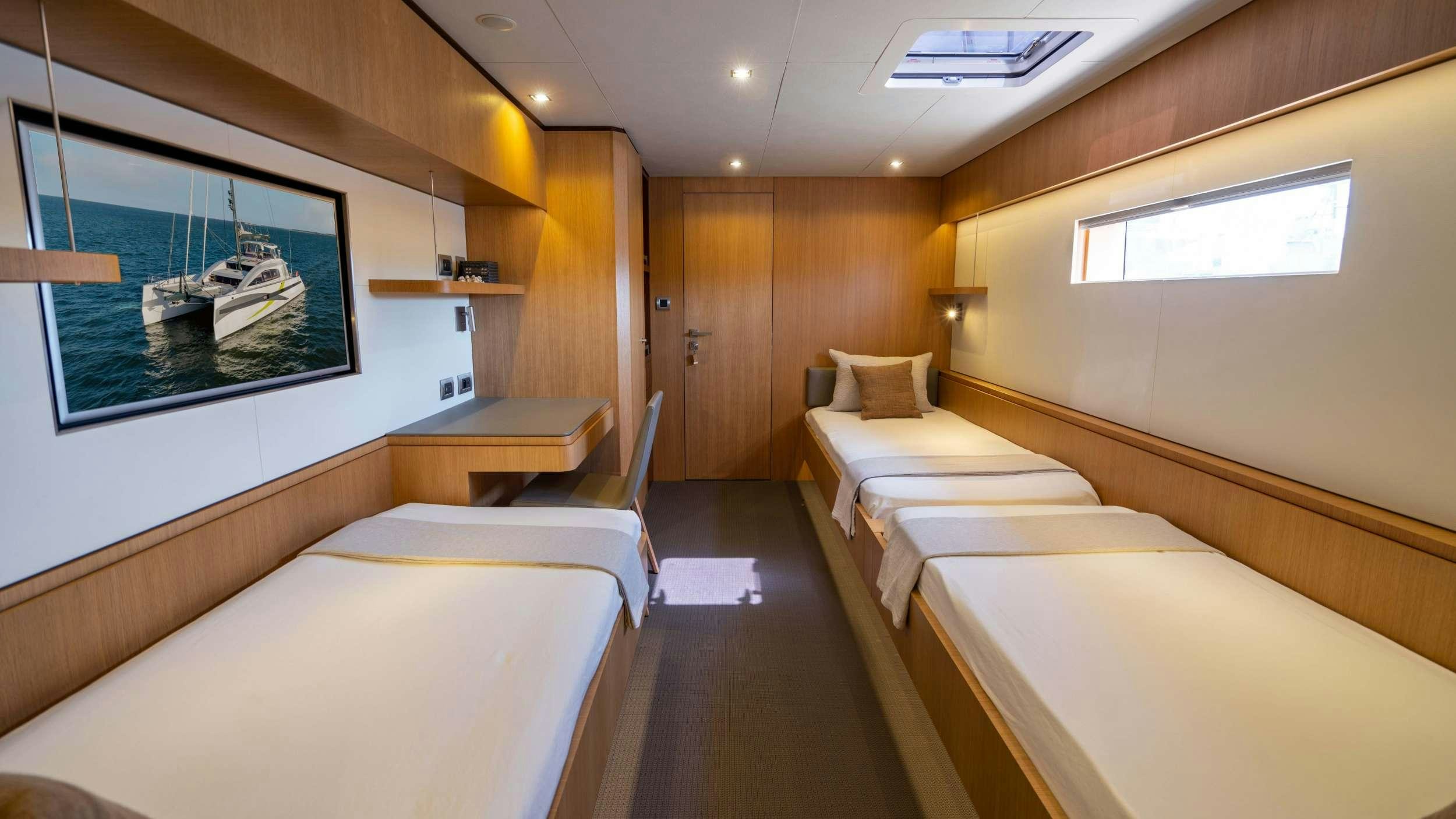a room with beds and a tv aboard NDS EVOLUTION Yacht for Charter