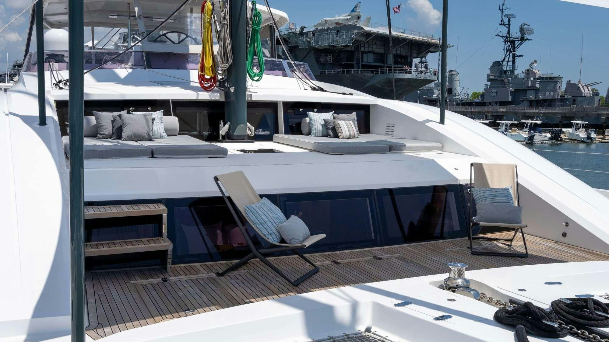 a deck with a chair and a boat on it aboard NDS EVOLUTION Yacht for Charter