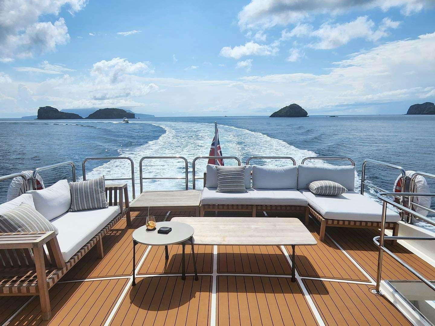 a deck with chairs and tables on it by the water aboard WW Yacht for Charter