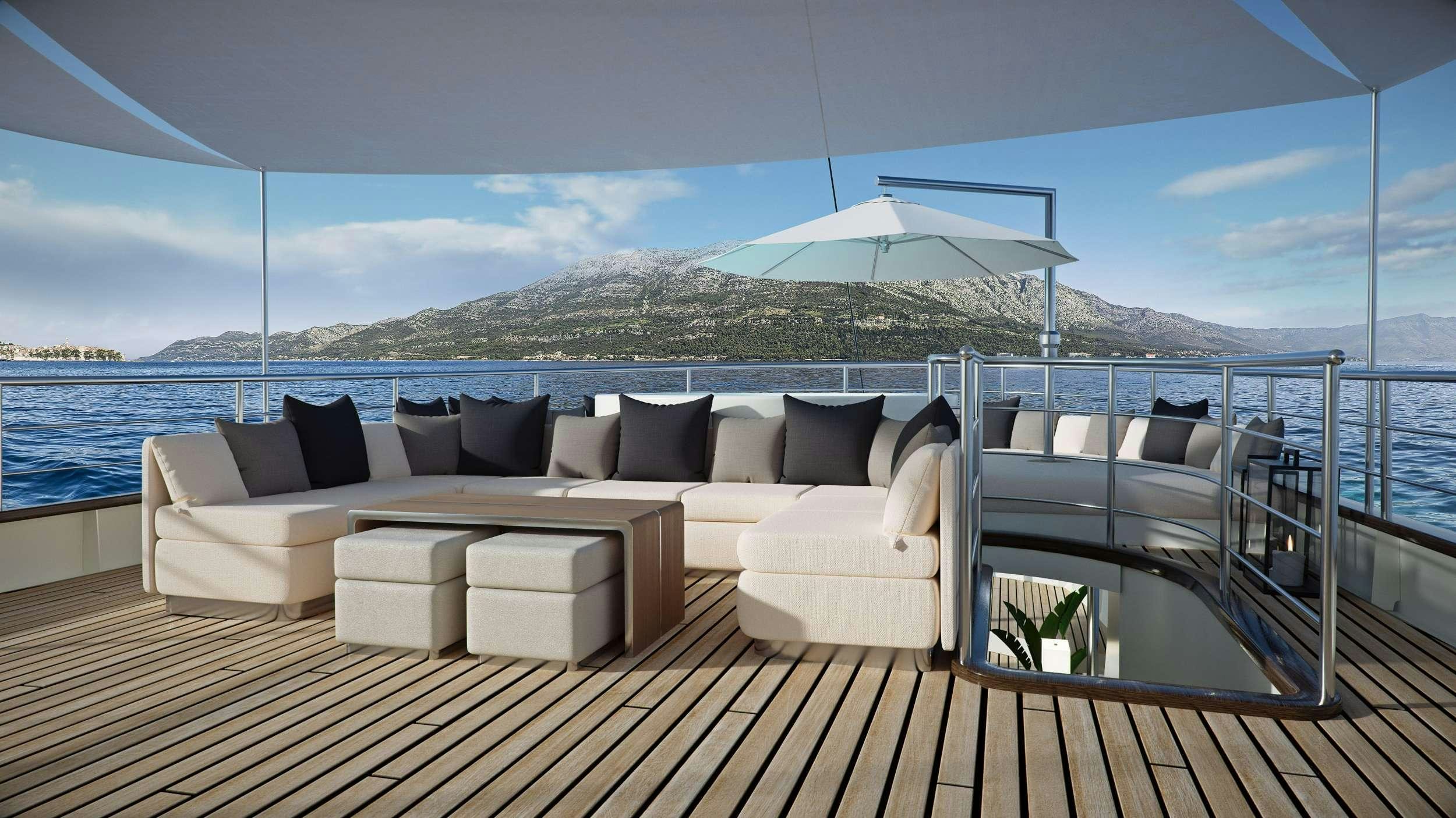 a large white couch on a deck overlooking a large body of water aboard MAIA Yacht for Charter