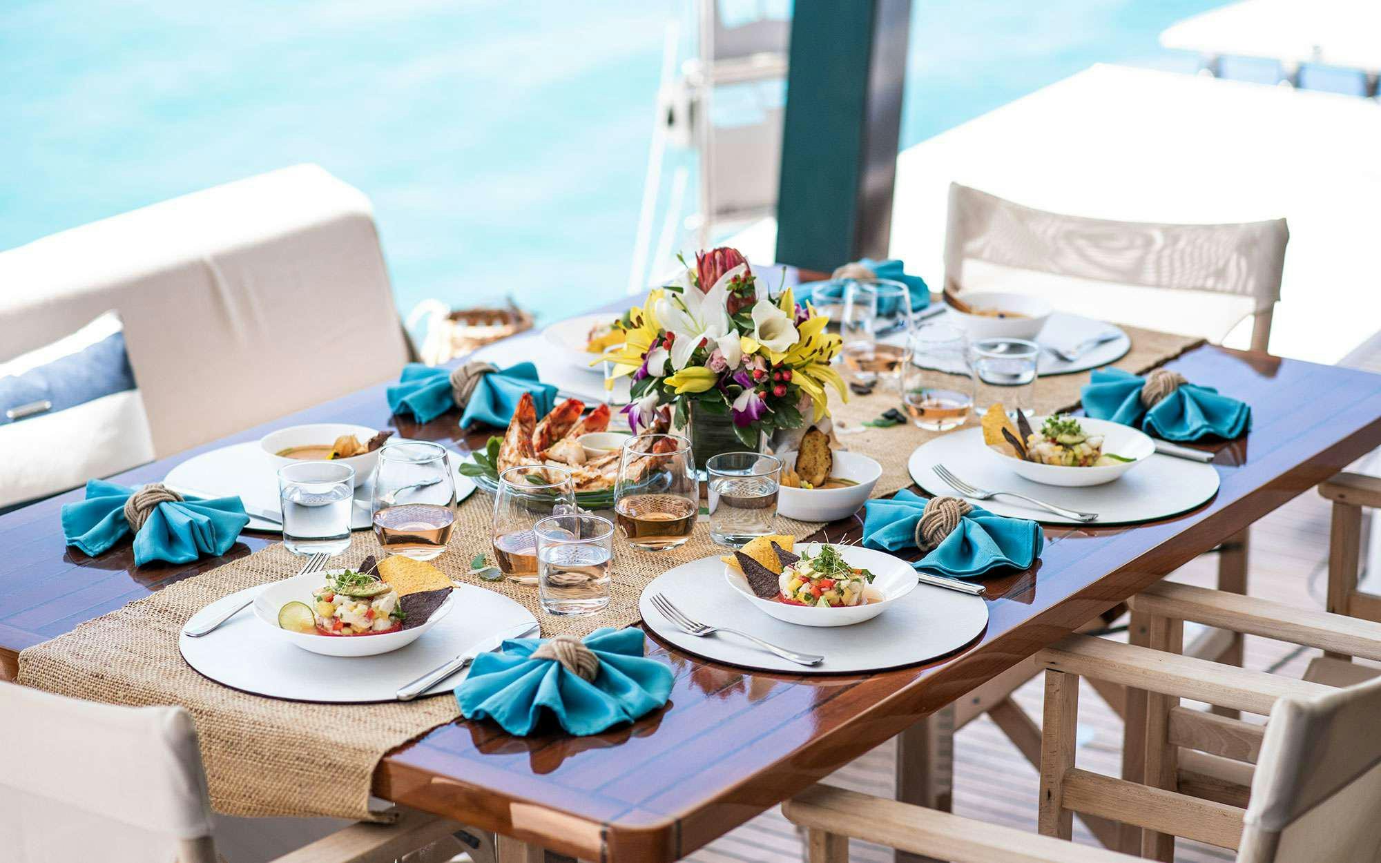 a table with plates and food on it aboard BUNDALONG Yacht for Charter