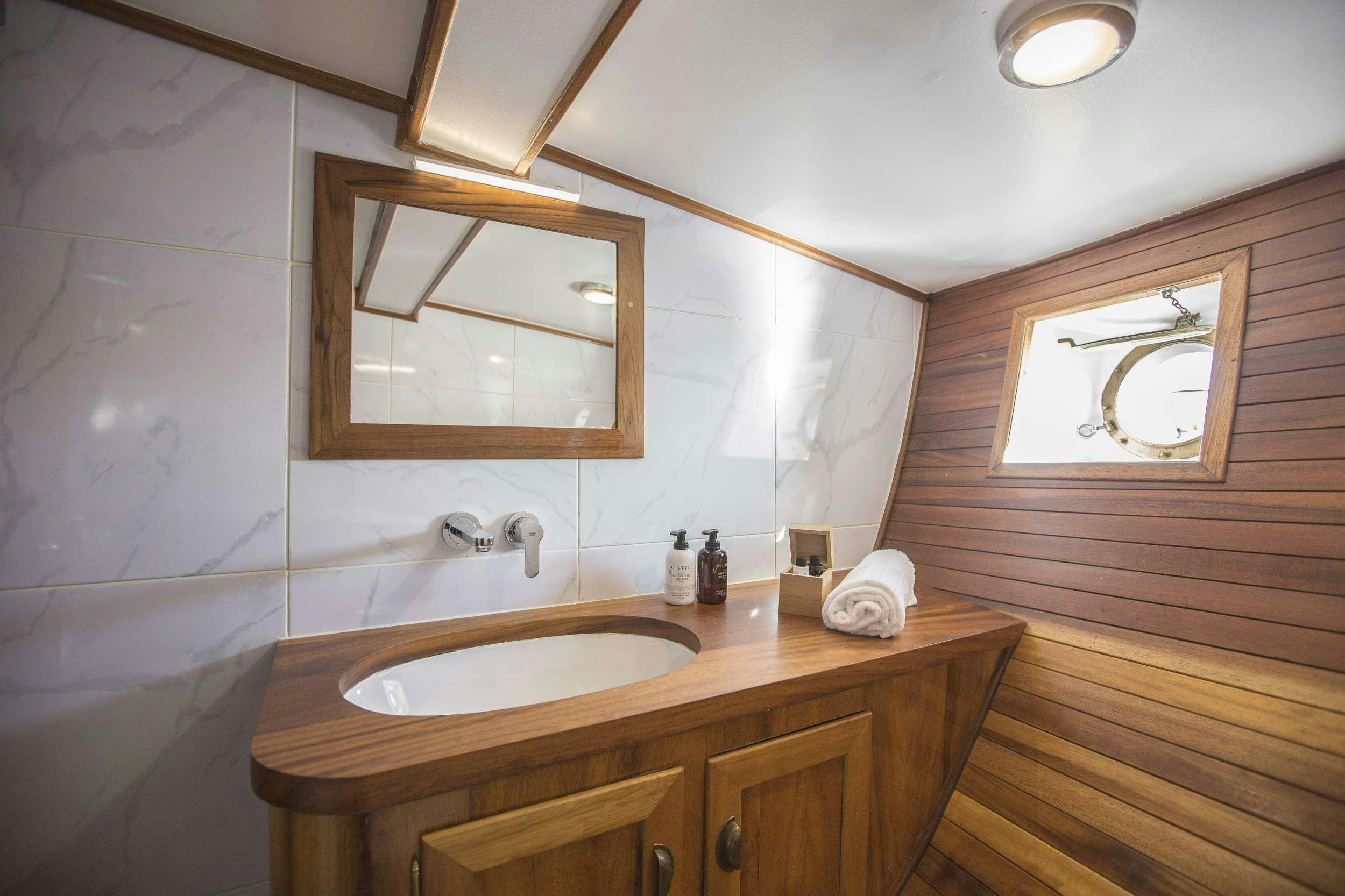 a bathroom with a sink and a mirror aboard COSMOS Yacht for Charter