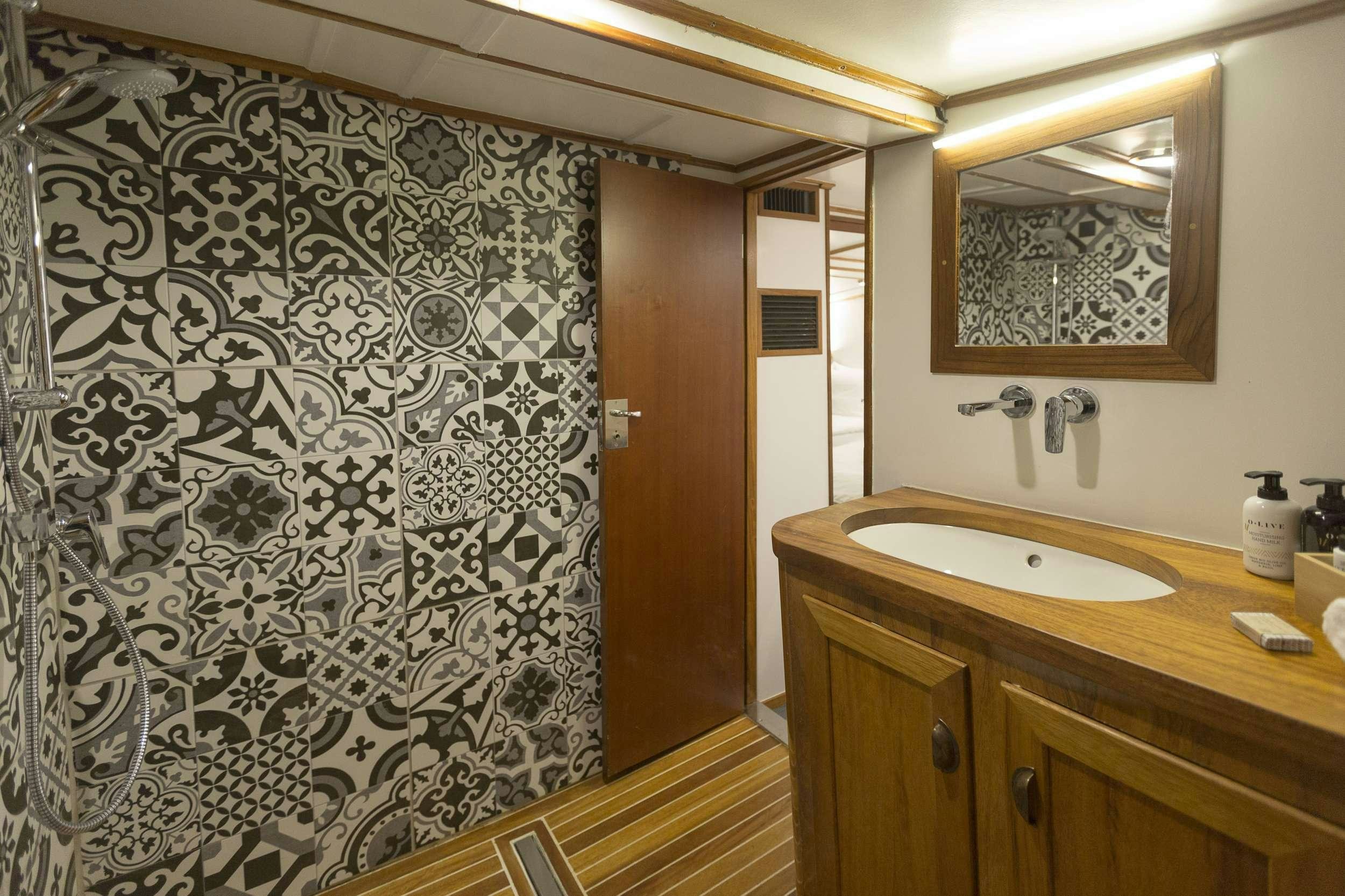 a bathroom with a sink and a mirror aboard COSMOS Yacht for Charter