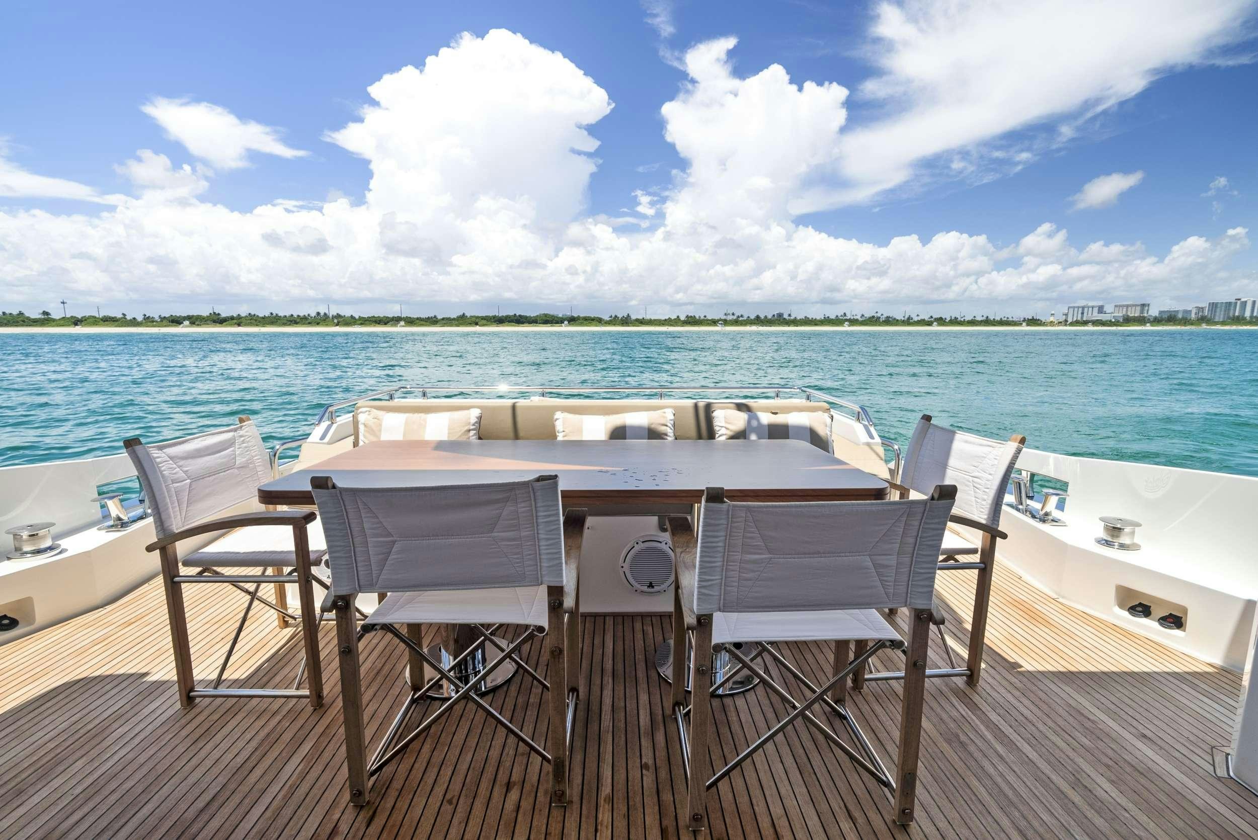 a table and chairs on a deck overlooking a body of water aboard FANTASTIC Yacht for Charter