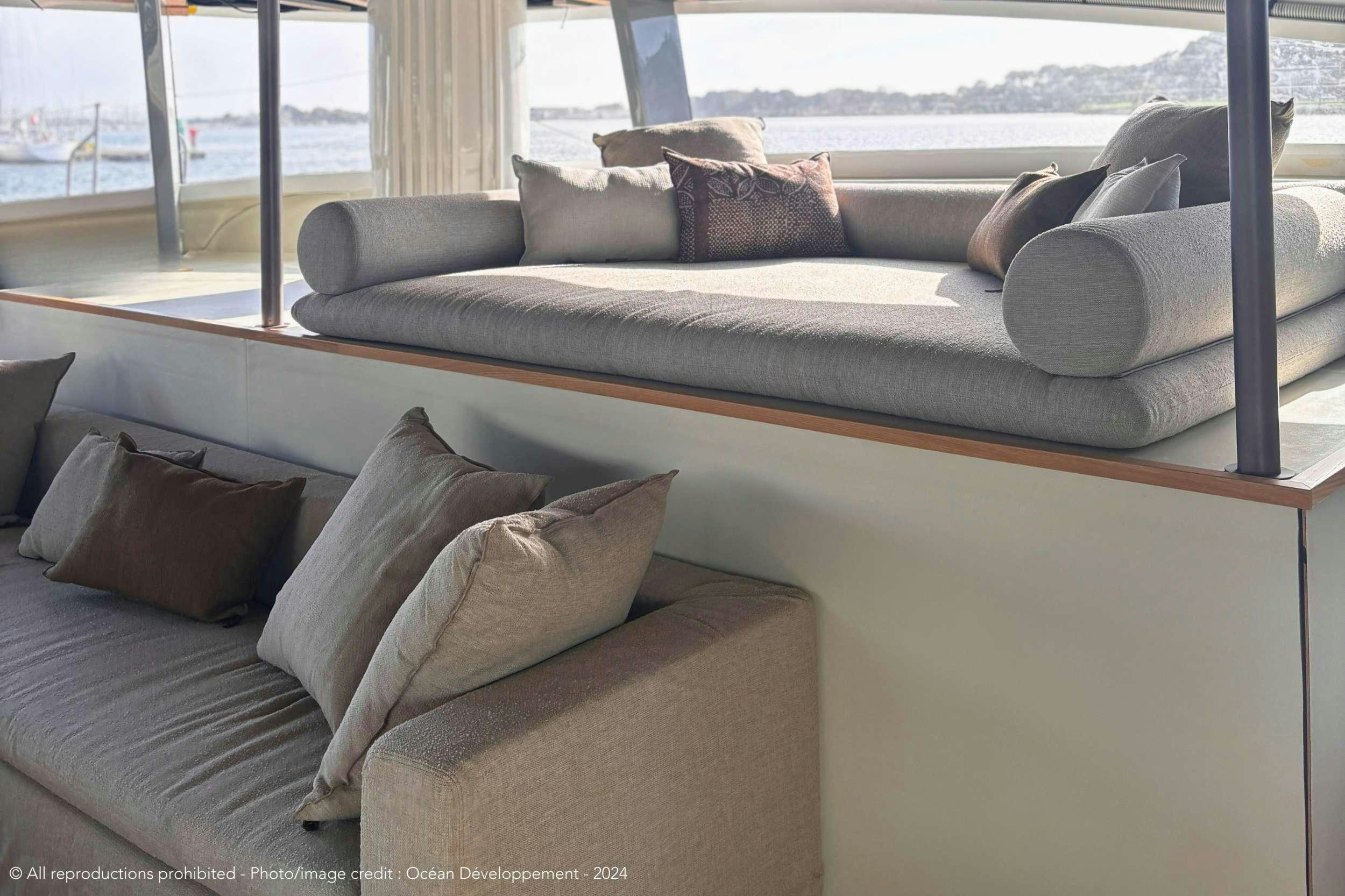 a couch with pillows aboard GANANY Yacht for Charter