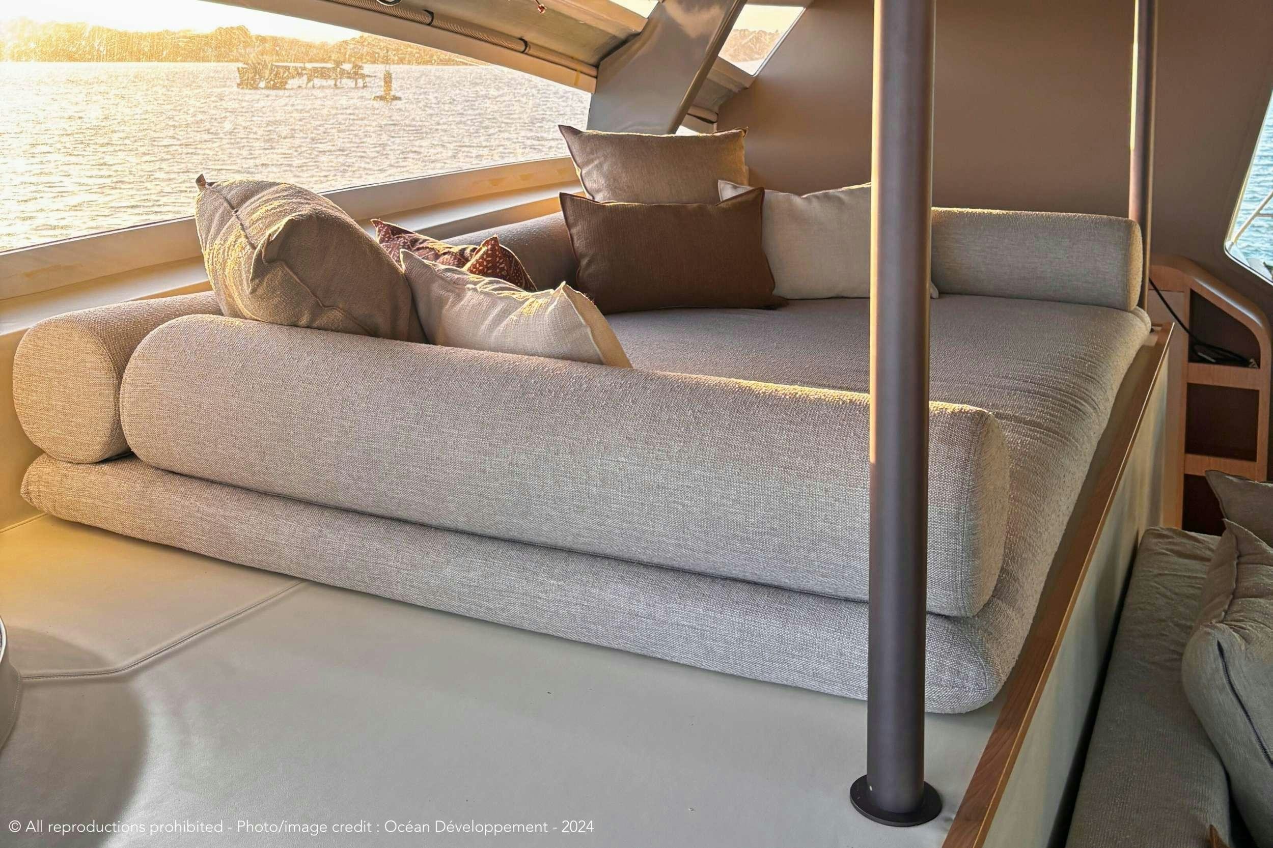 a couch with a pillow on it aboard GANANY Yacht for Charter