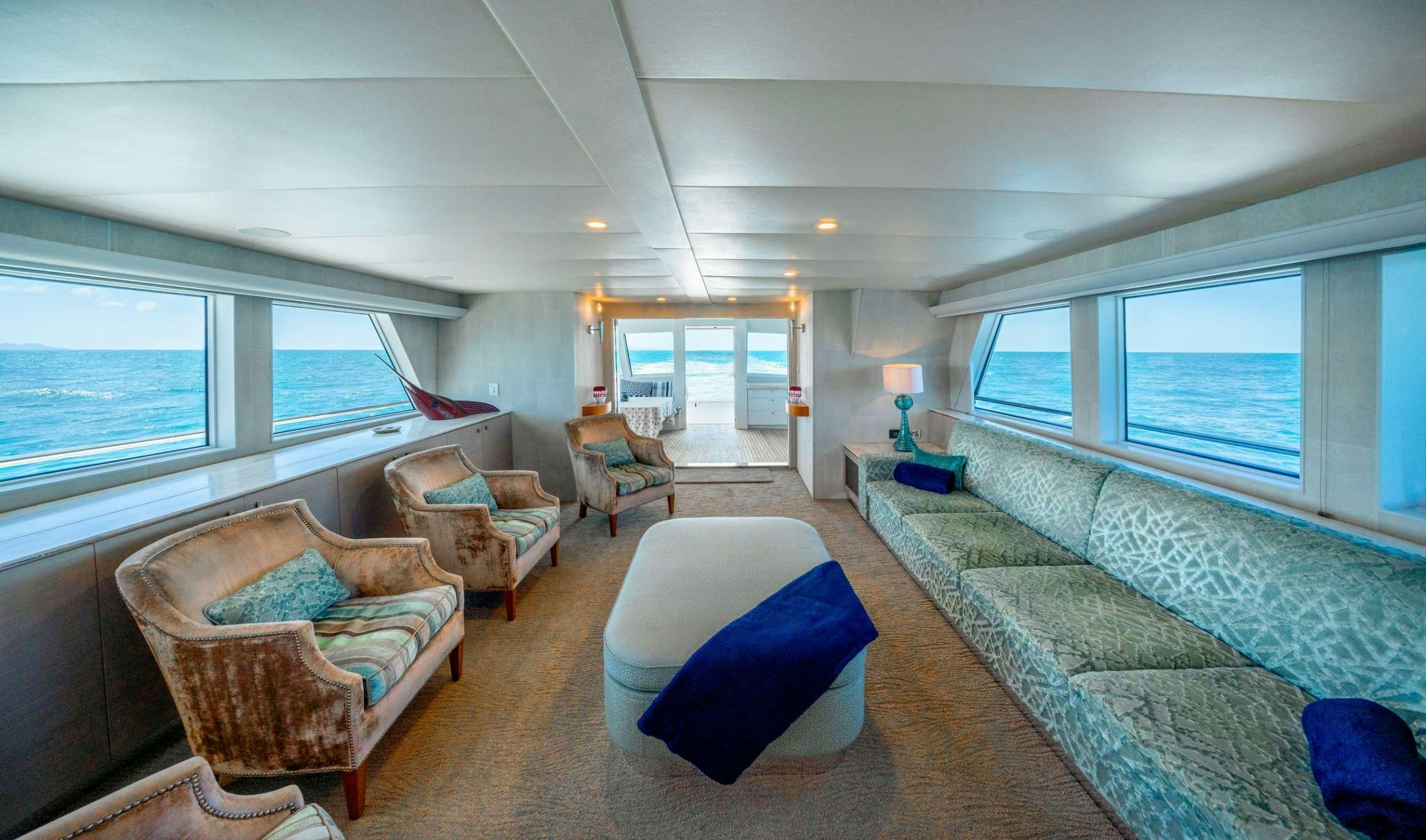 a living room with a couch and a large window aboard SHORETHING Yacht for Charter