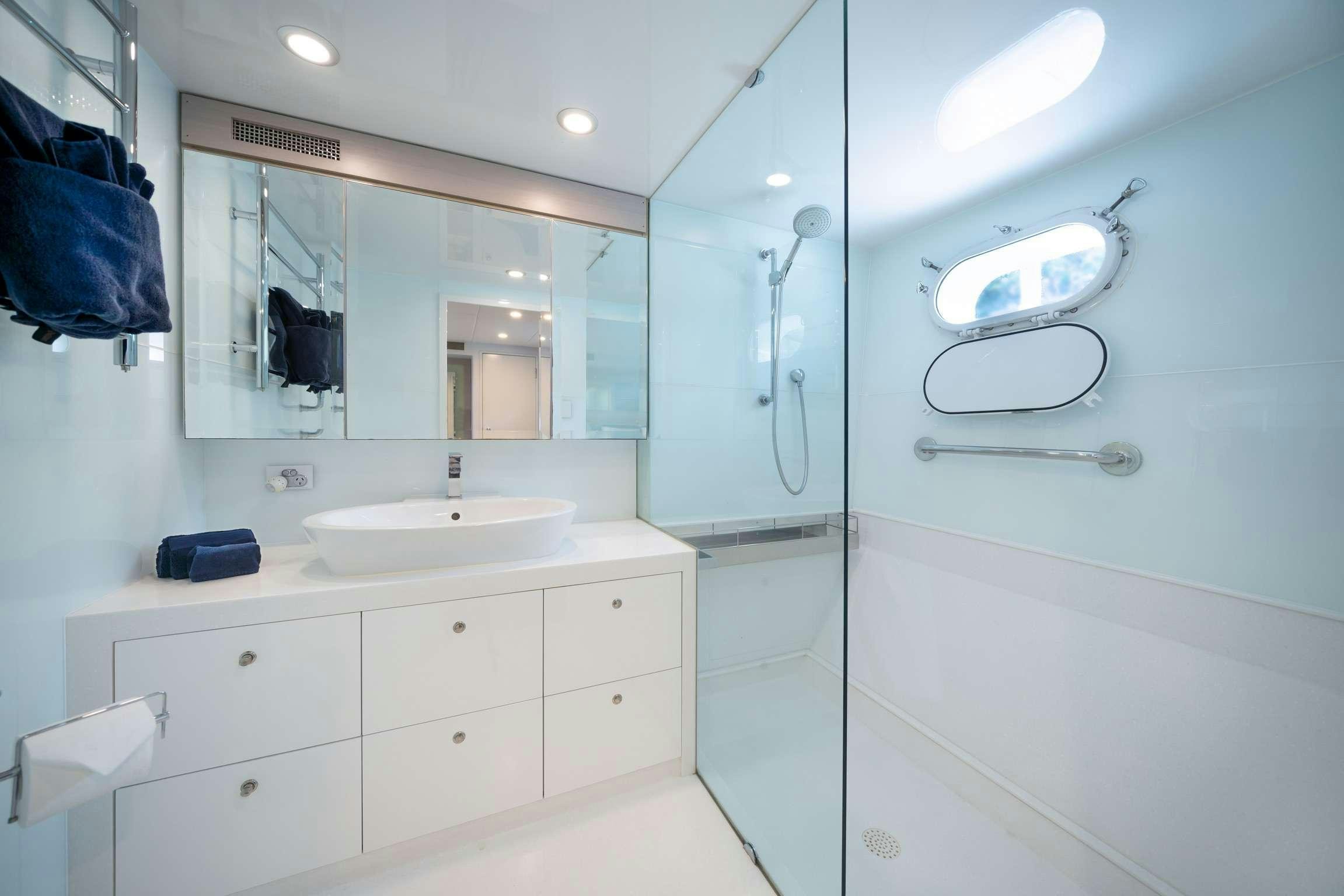 a bathroom with a sink and mirror aboard SHORETHING Yacht for Charter