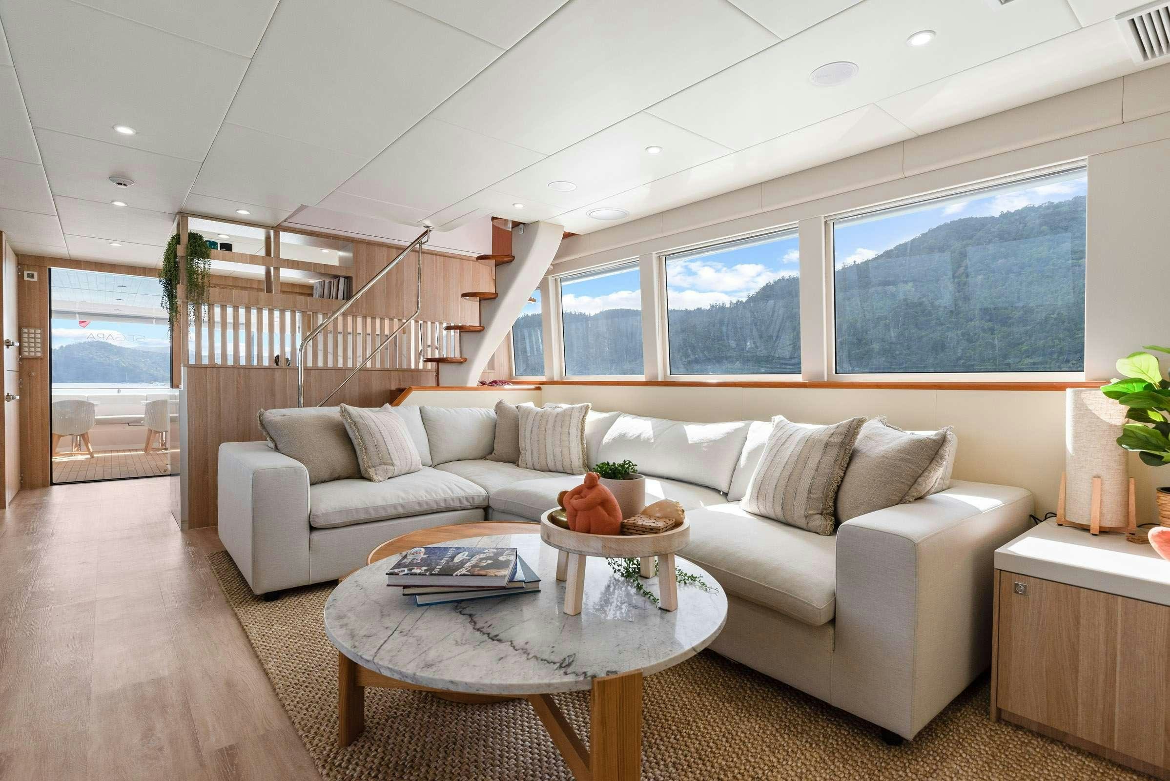 a living room with a white couch and a staircase aboard MATRIX III Yacht for Charter