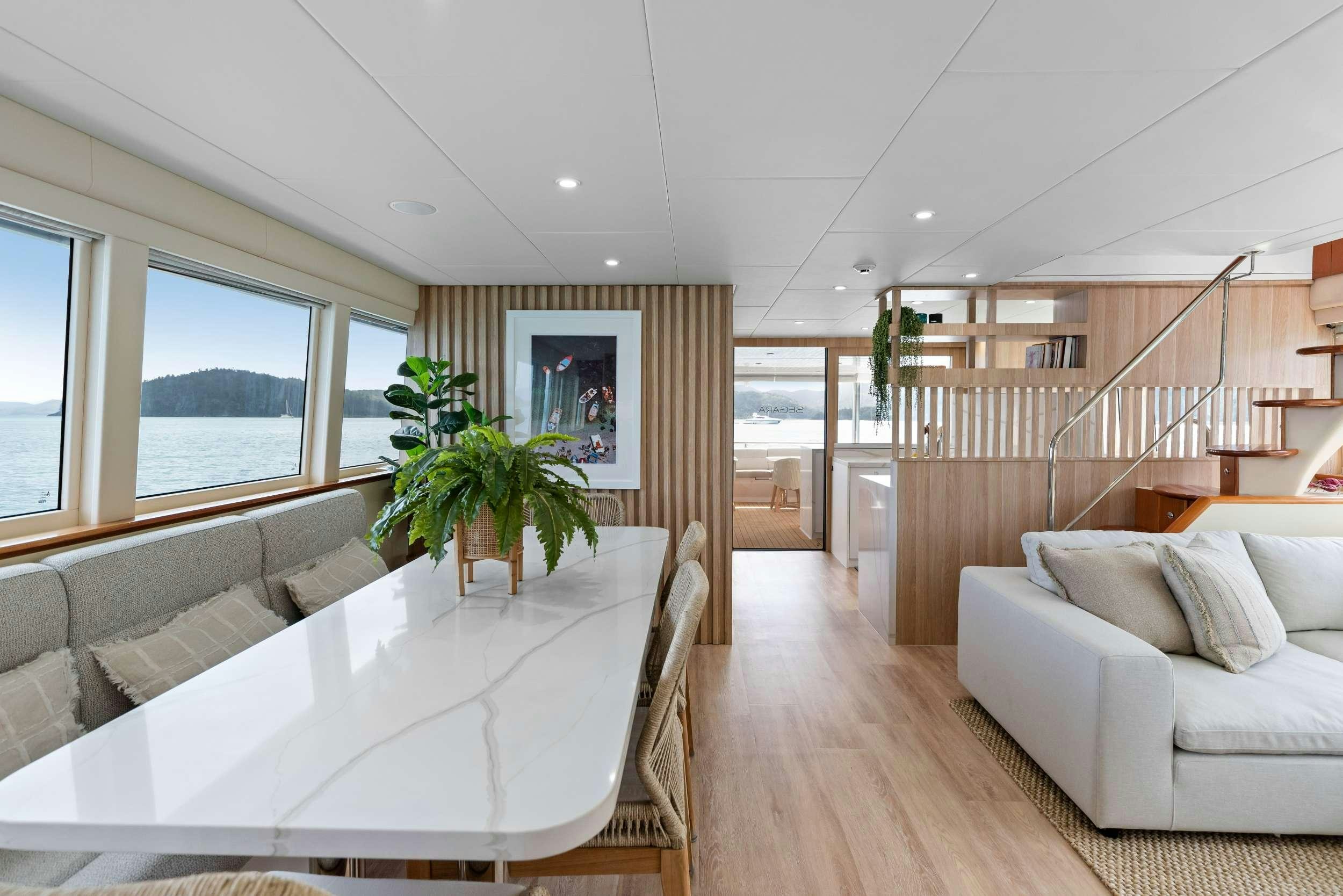 a room with a table and couch aboard MATRIX III Yacht for Charter