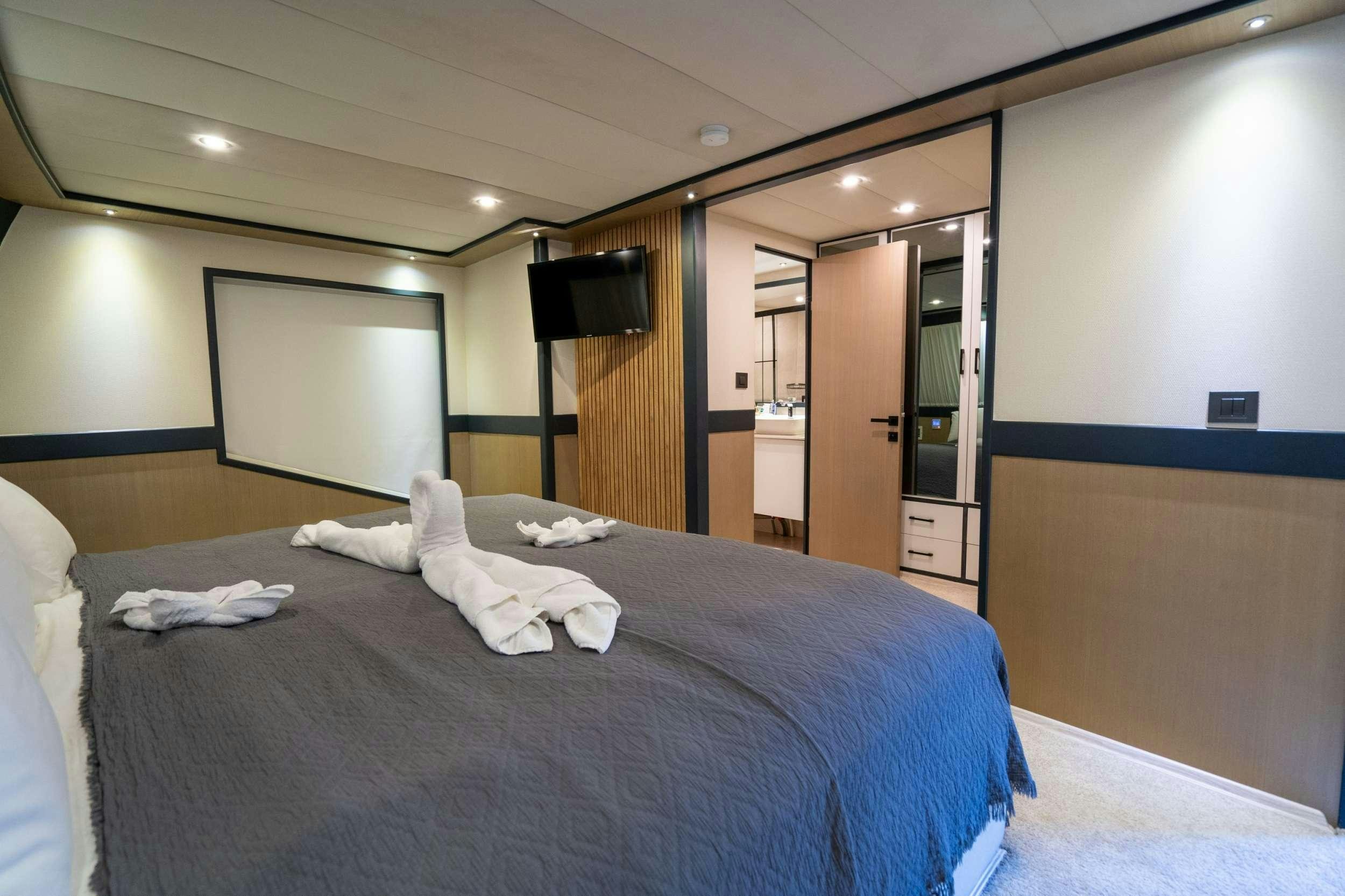 a hotel room with a bed and tv aboard IMPACT Yacht for Charter