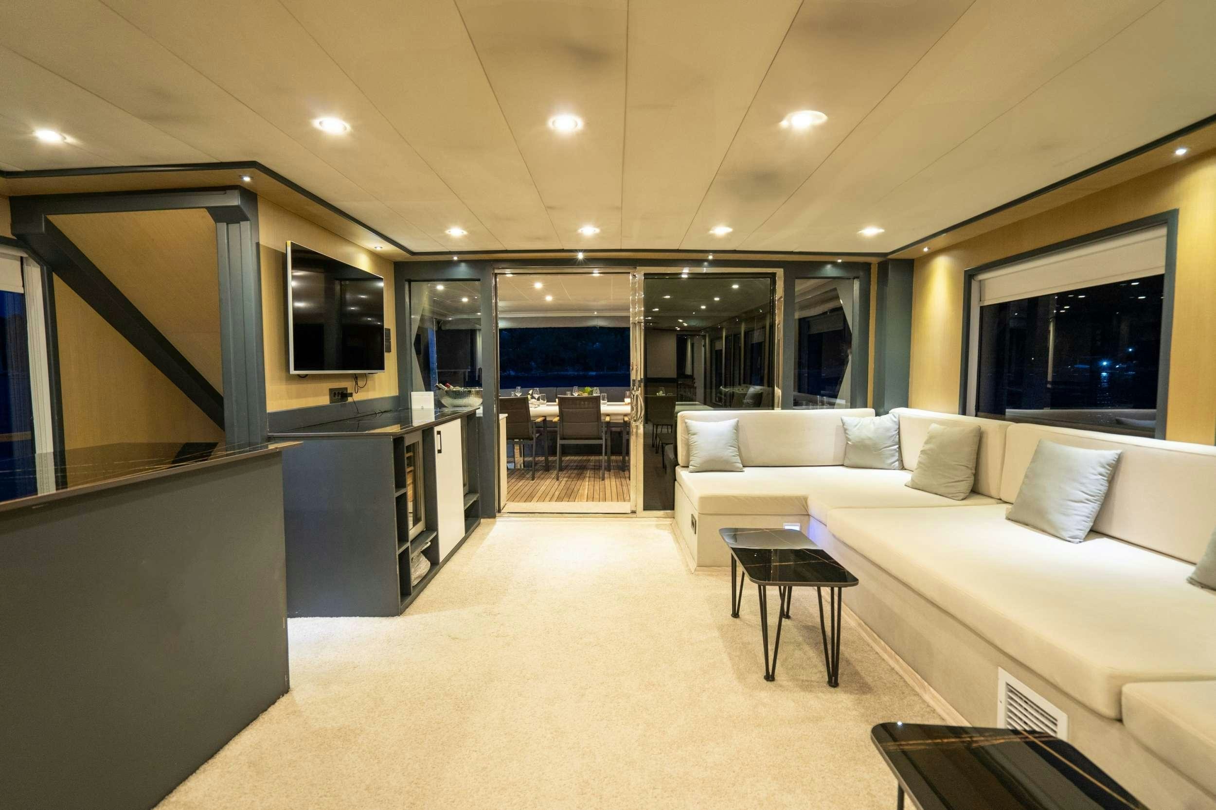 a large room with a couch and a table aboard IMPACT Yacht for Charter