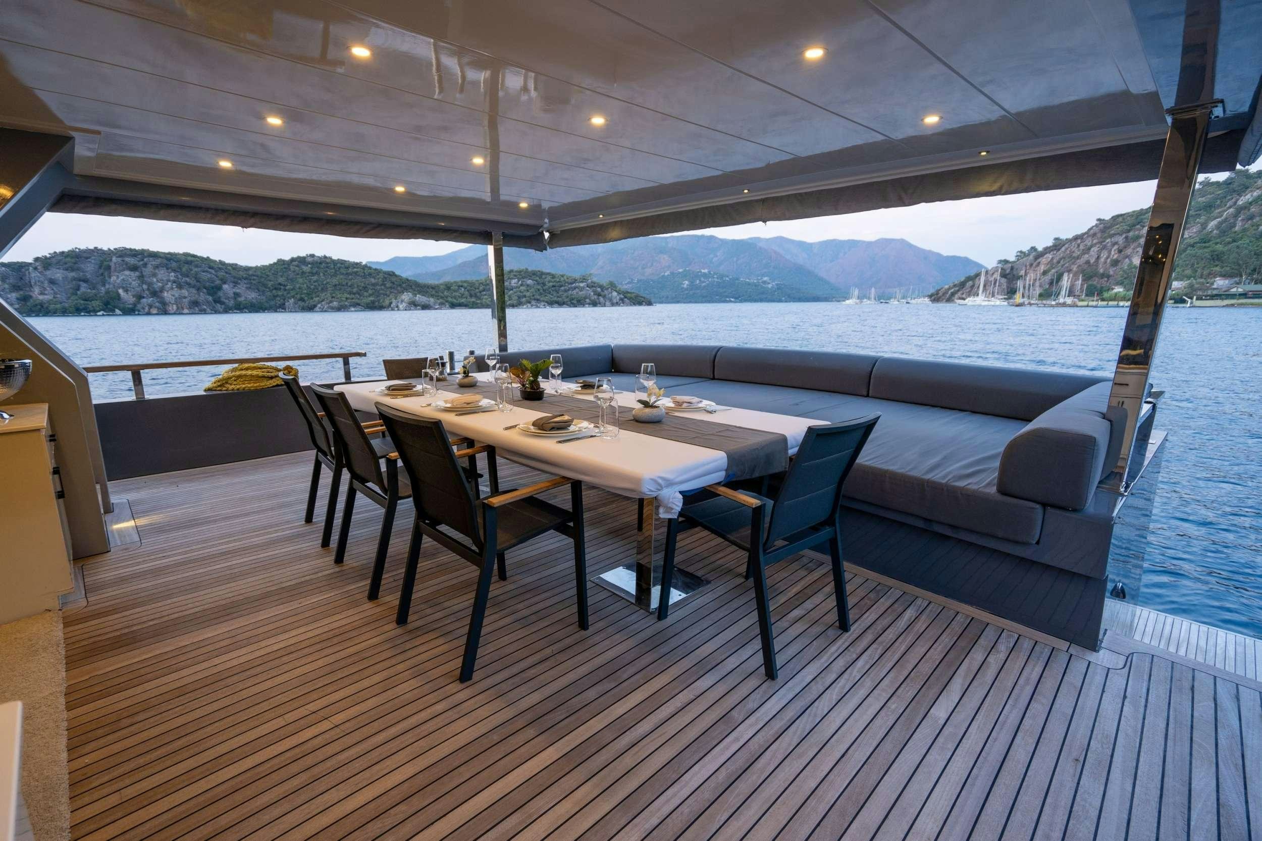 a table and chairs on a deck aboard IMPACT Yacht for Charter