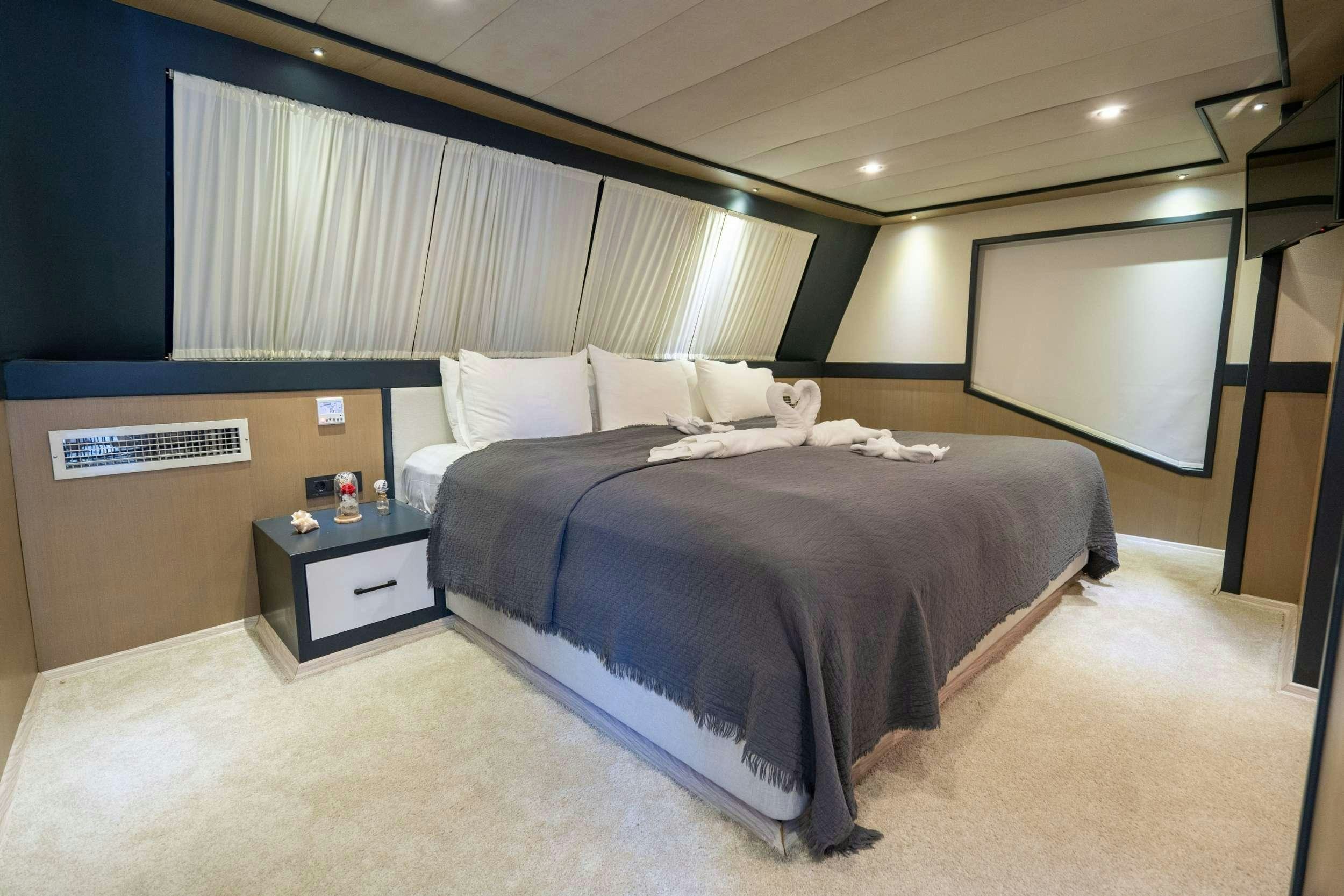 a bedroom with a bed and a desk aboard IMPACT Yacht for Charter