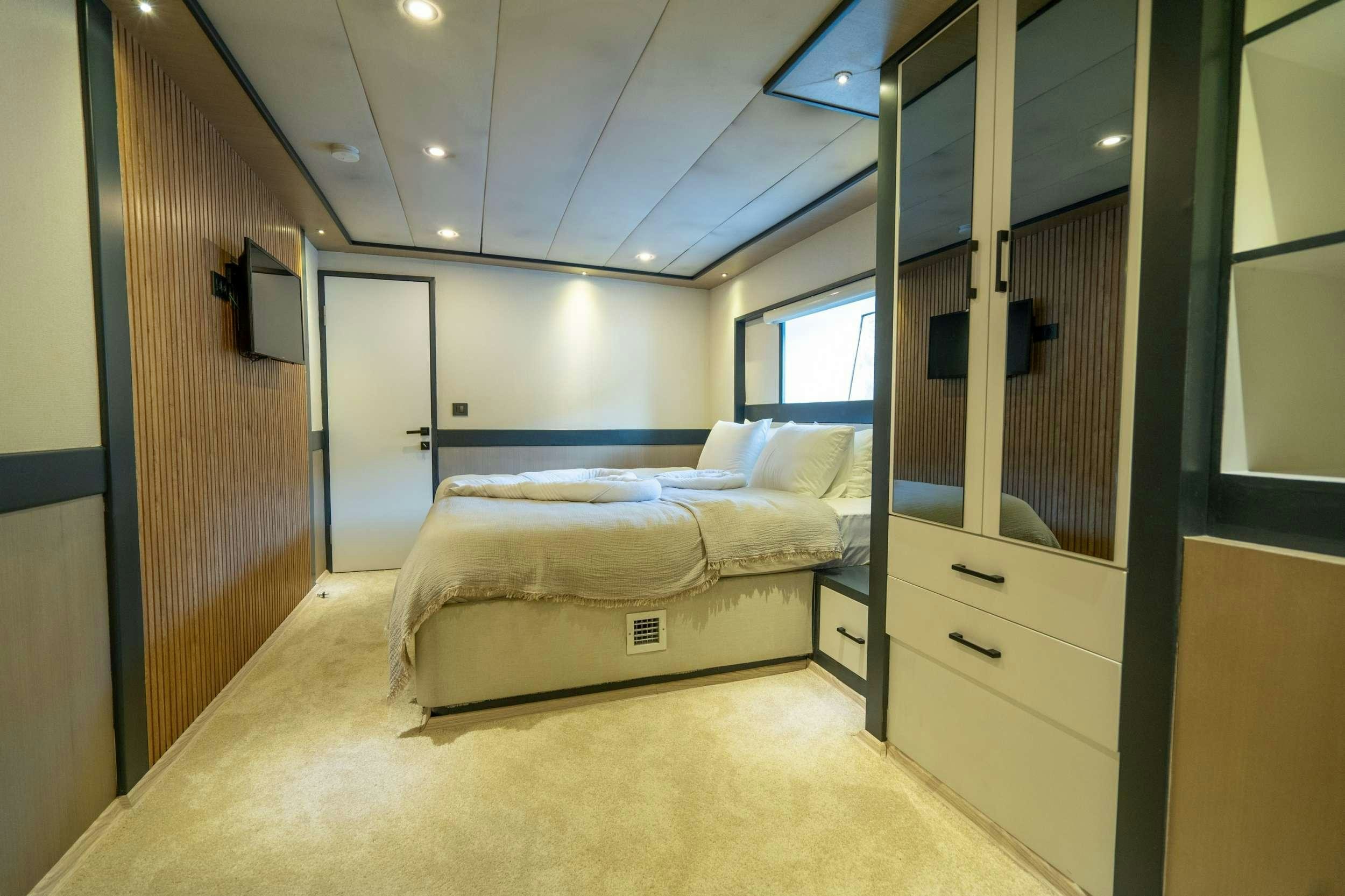 a bedroom with a bed and a television aboard IMPACT Yacht for Charter