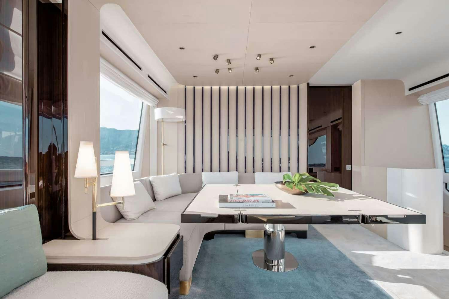 a living room with a table and couches aboard DT78 Yacht for Charter