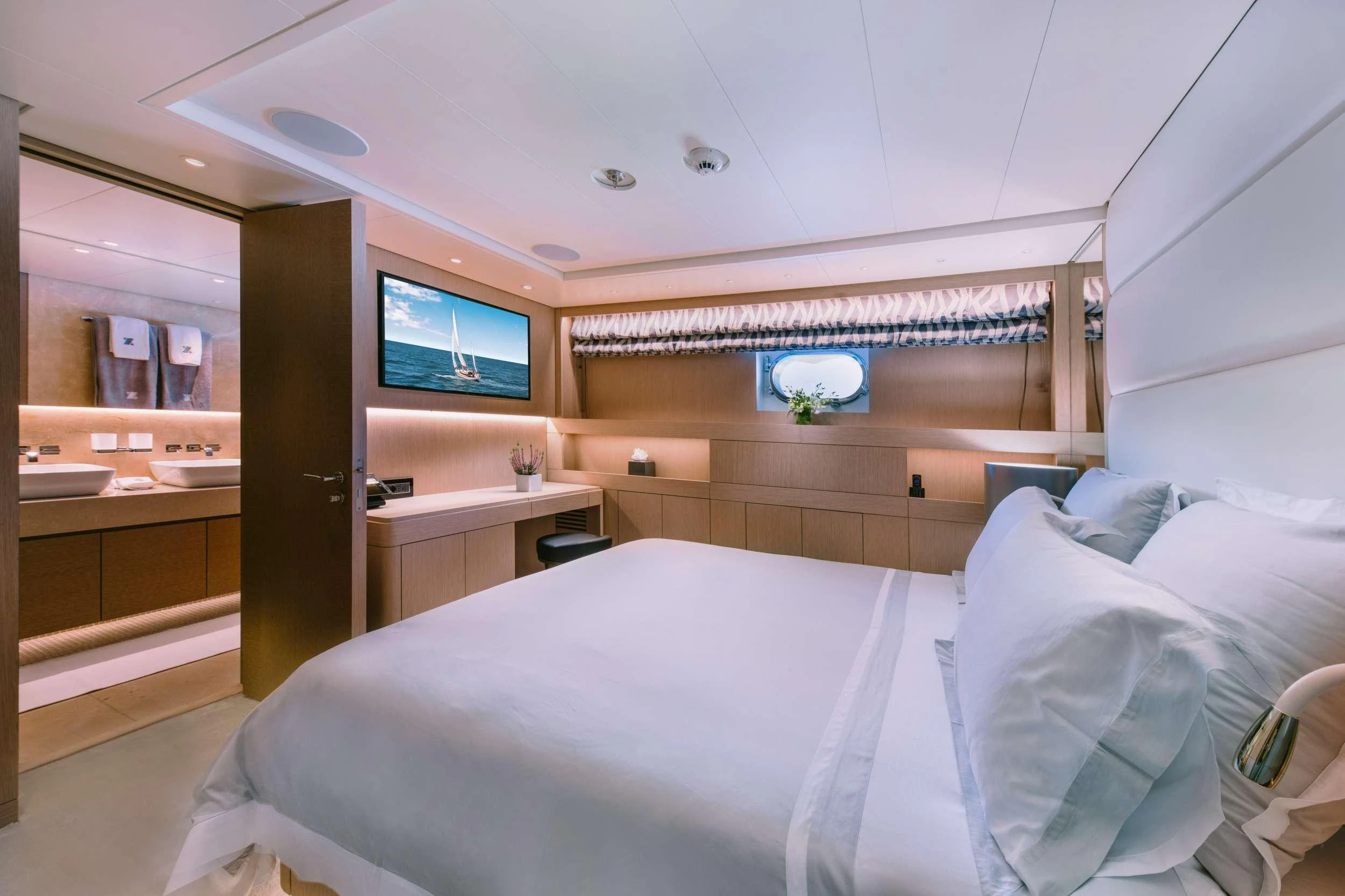 a room with a bed and a tv on the wall aboard XANA Yacht for Charter