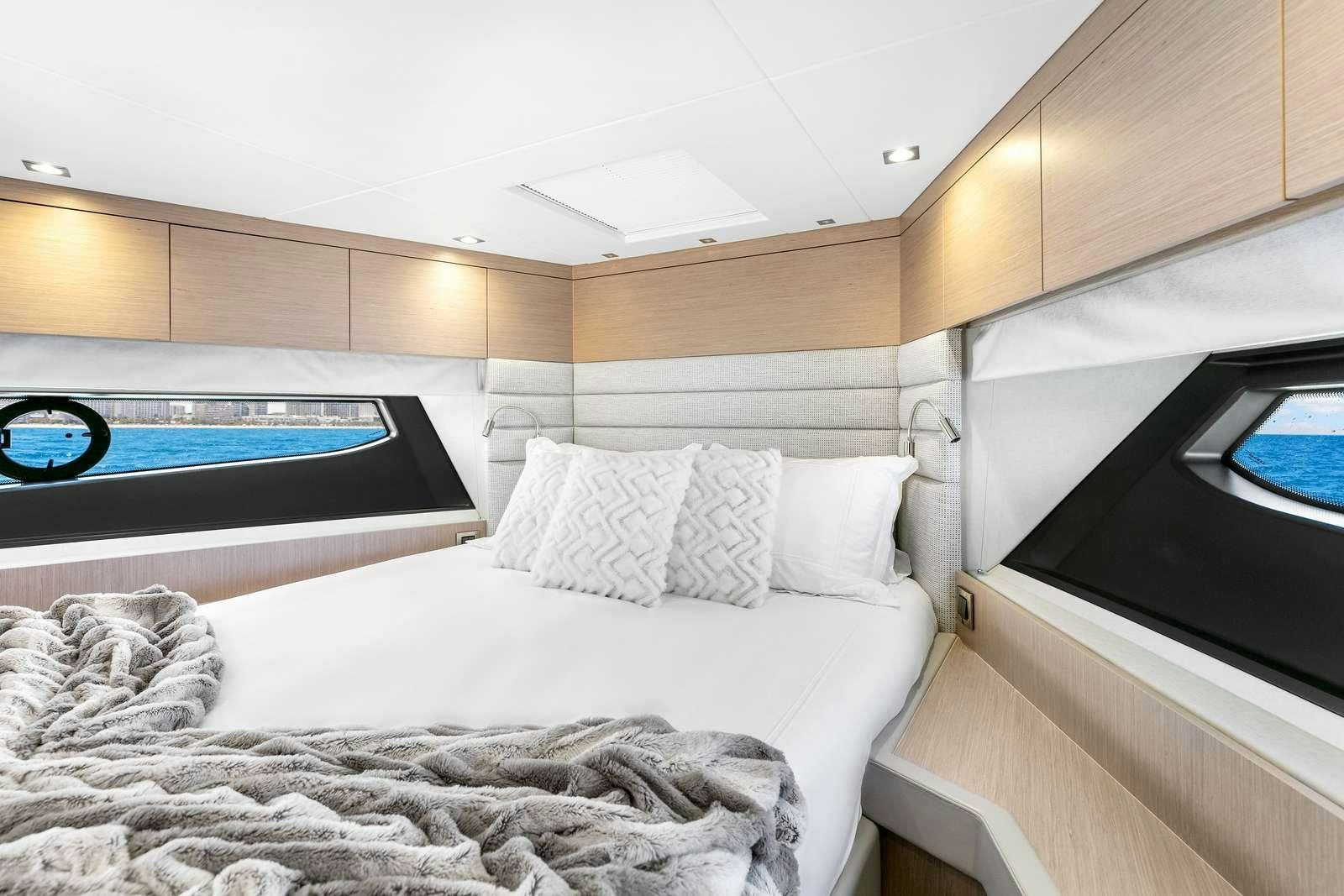 a bedroom with a bed and a television aboard DONE DEAL Yacht for Charter