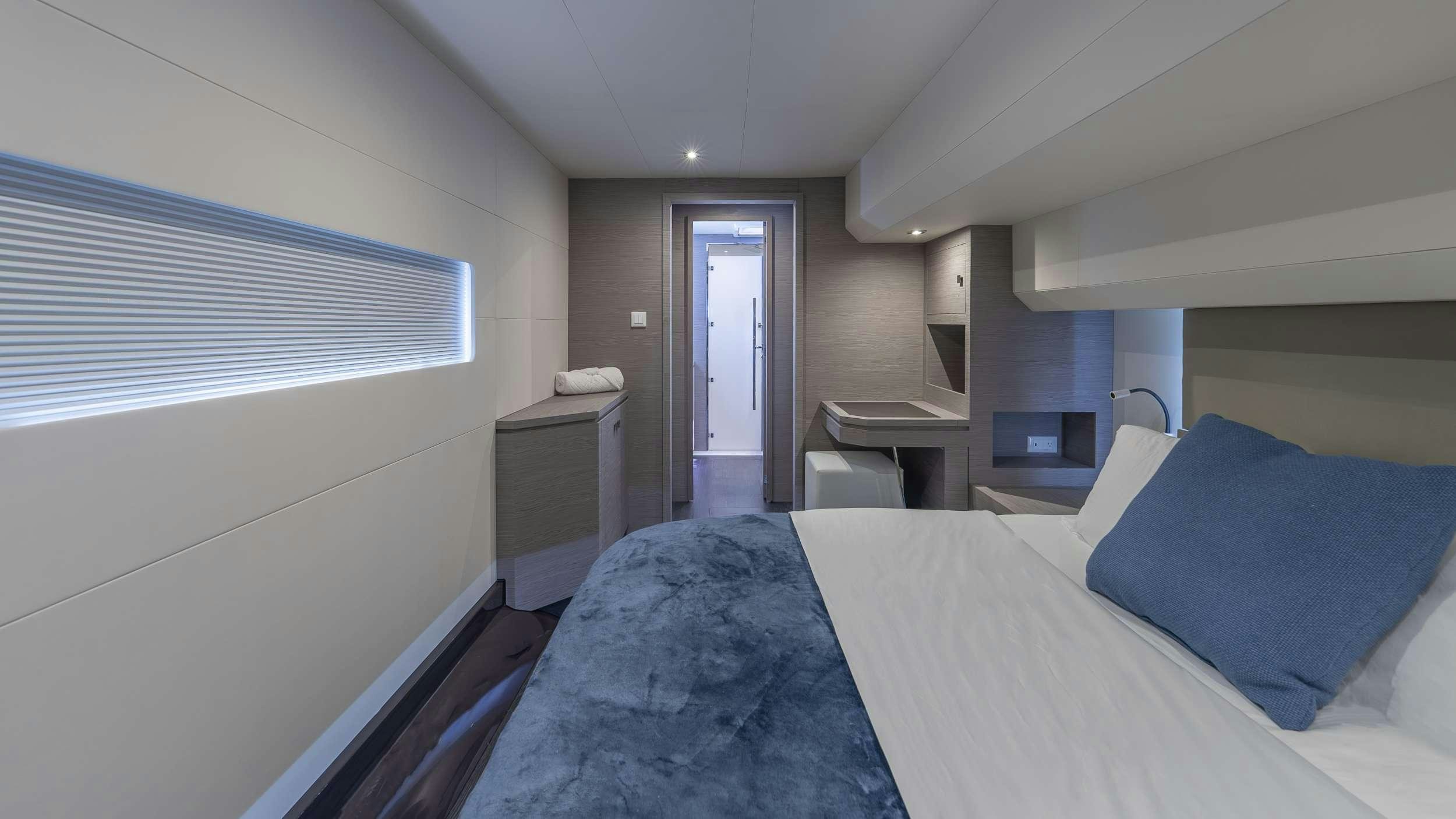 a room with a bed and a desk aboard PRINCESS Yacht for Charter
