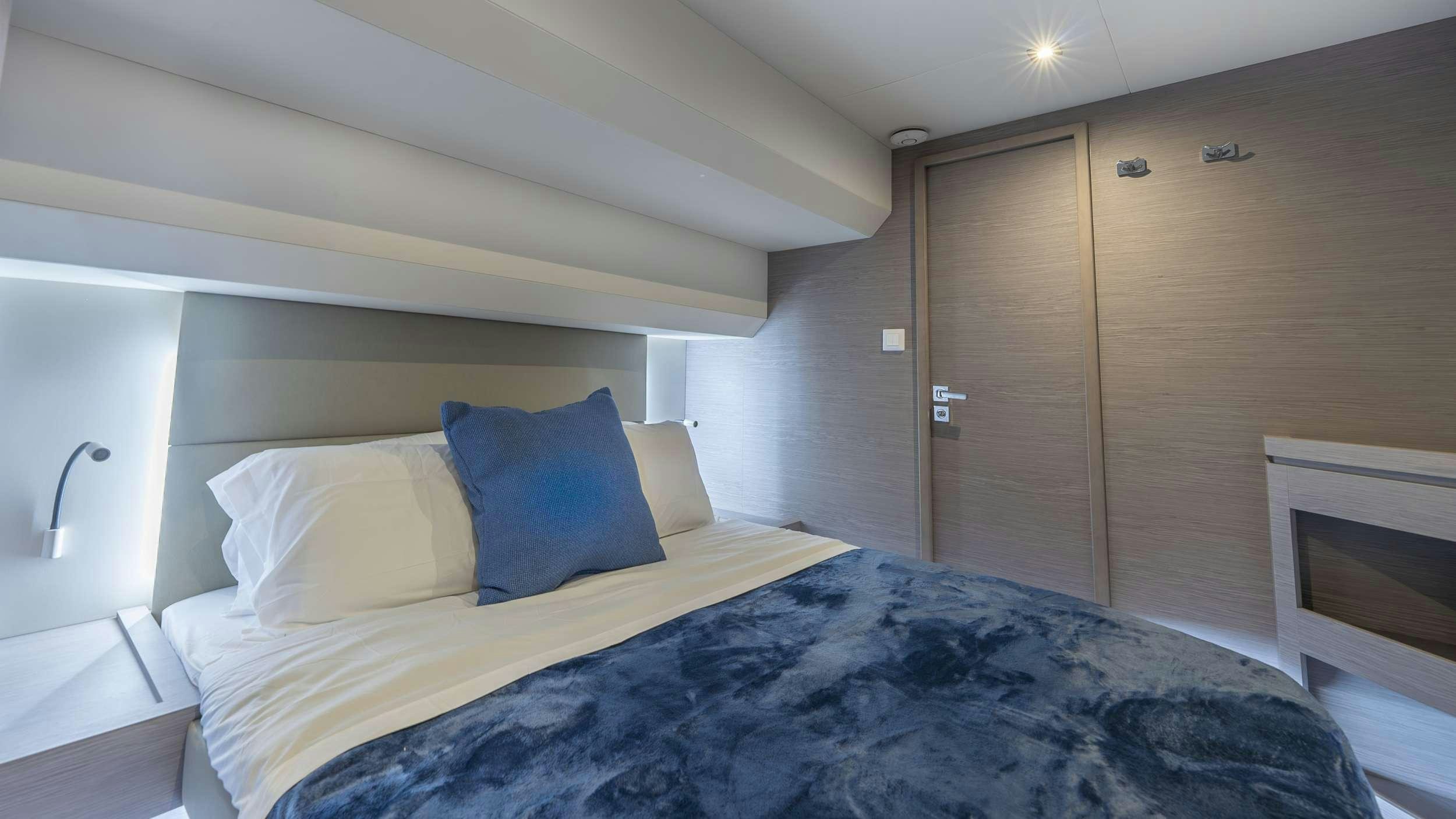a bed with blue sheets aboard PRINCESS Yacht for Charter