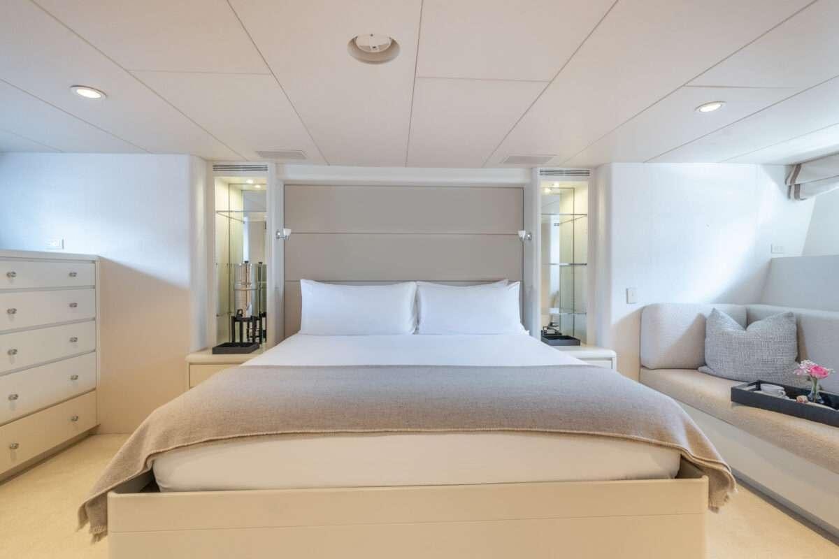a bedroom with a bed and a desk aboard CHANSON Yacht for Charter