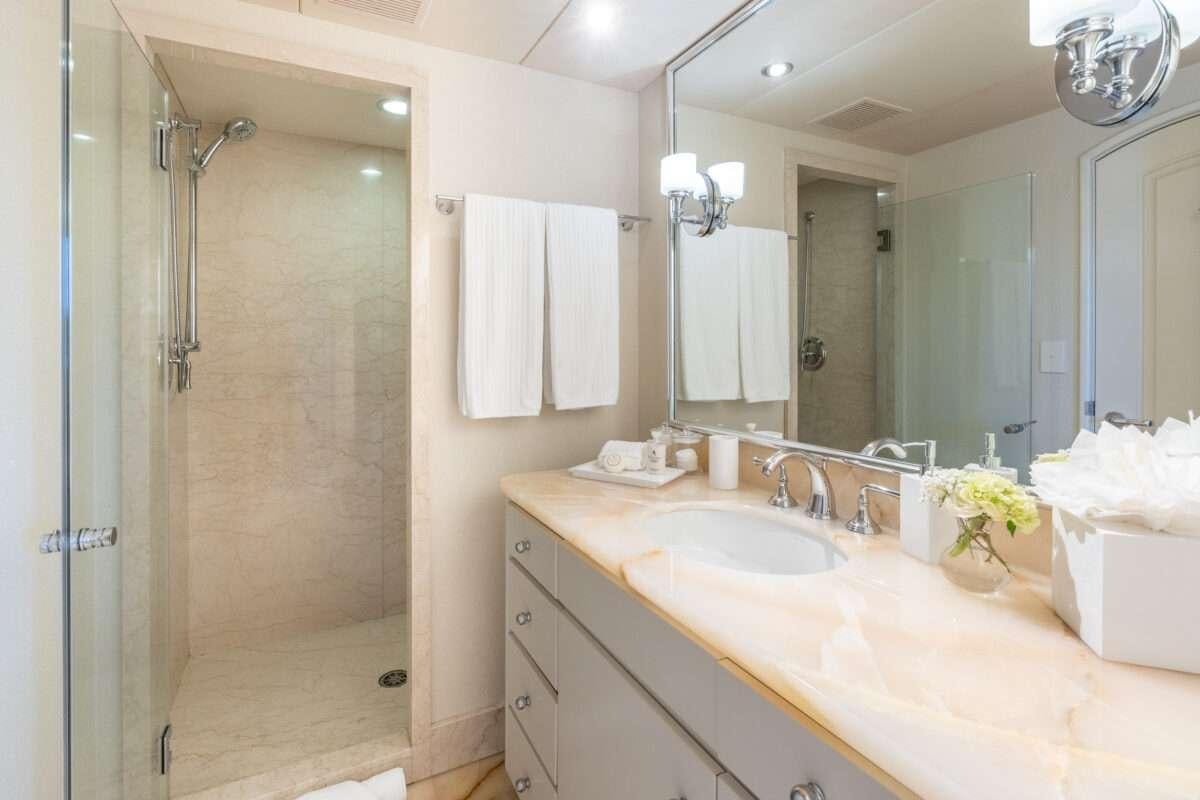a bathroom with a shower sink and a mirror aboard CHANSON Yacht for Charter
