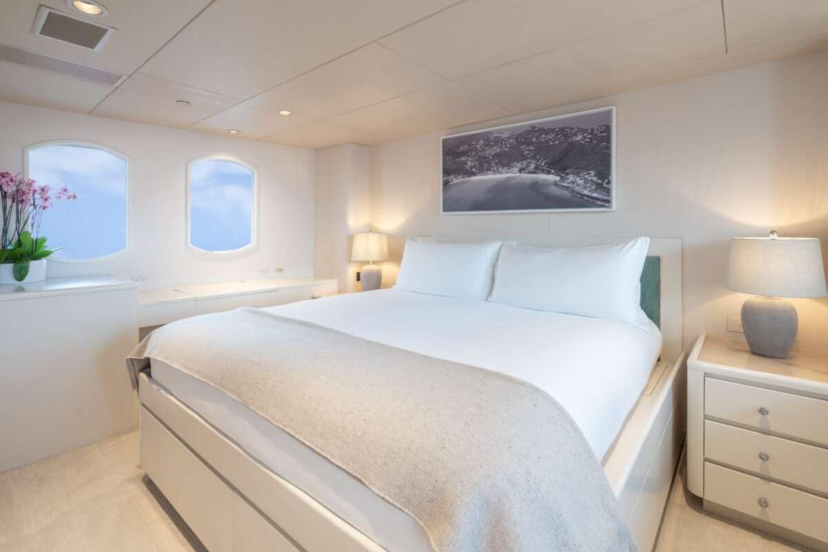 a bed with white sheets and pillows aboard CHANSON Yacht for Charter