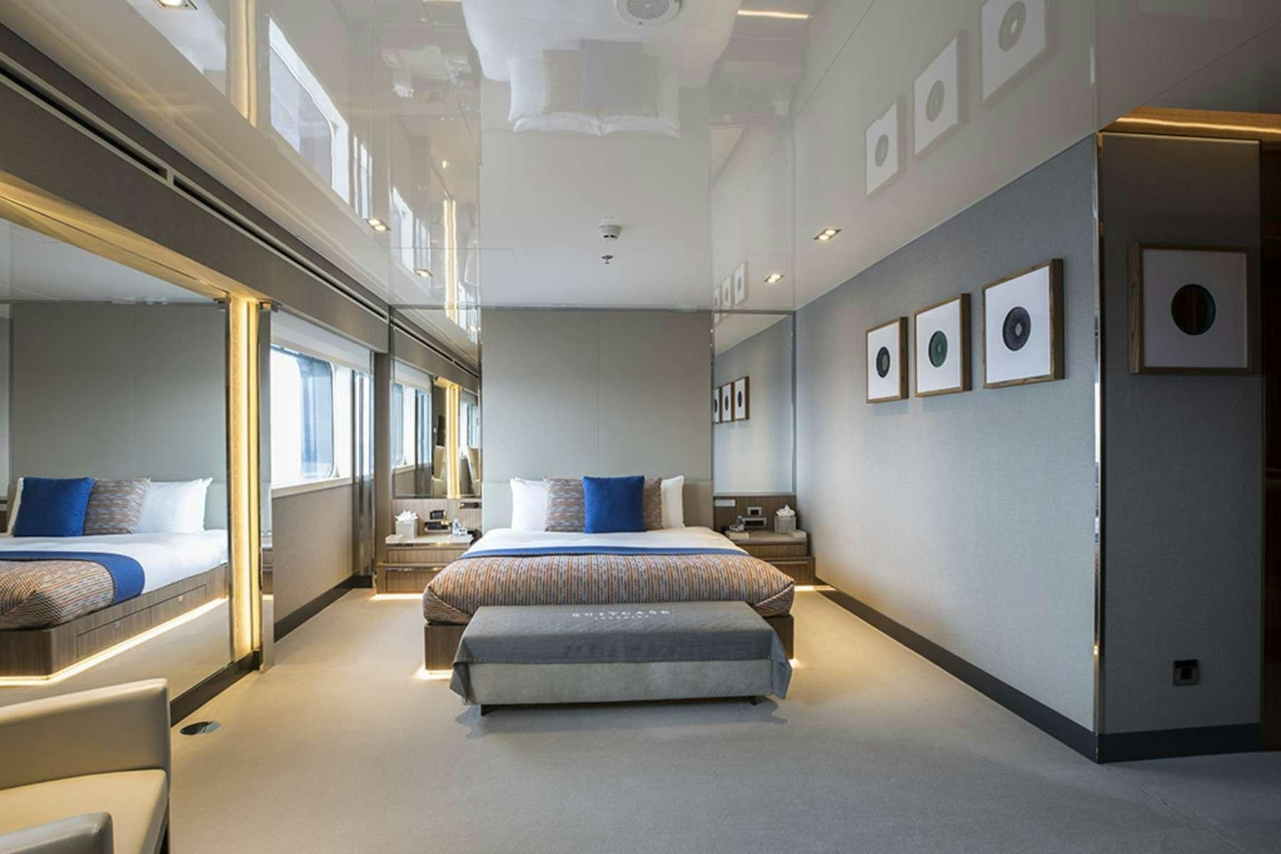 a room with a bed and a desk aboard SERENITY Yacht for Charter