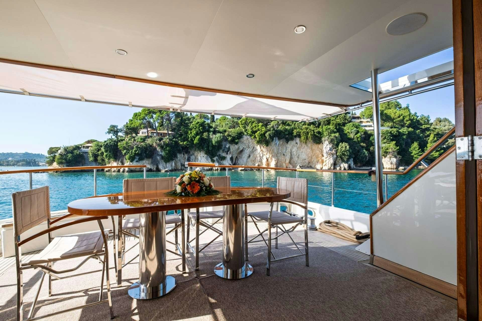 a table and chairs on a balcony aboard STALCA Yacht for Charter